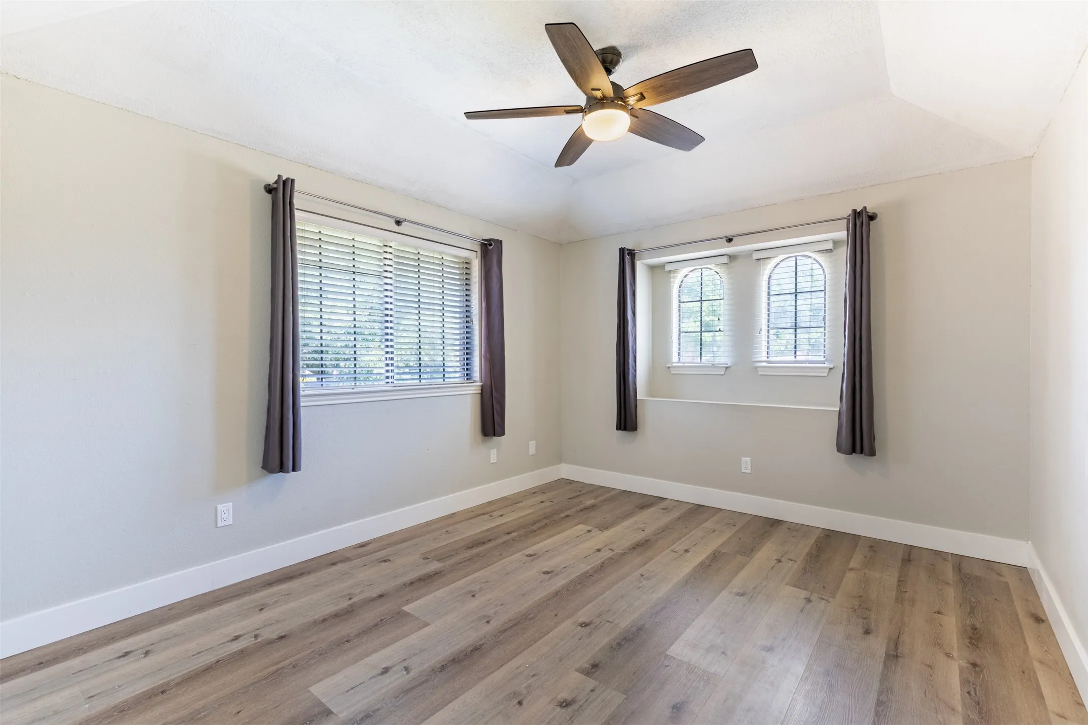 Upstairs secondary bedroom with ceiling fan.