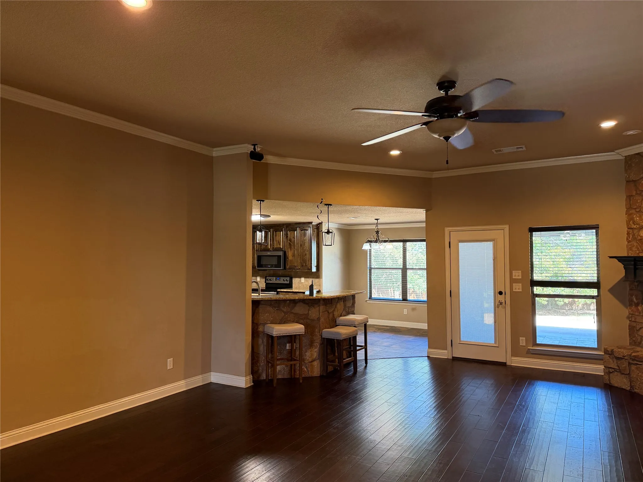 Dark wood-finish flooring, recessed lighting, and crown molding