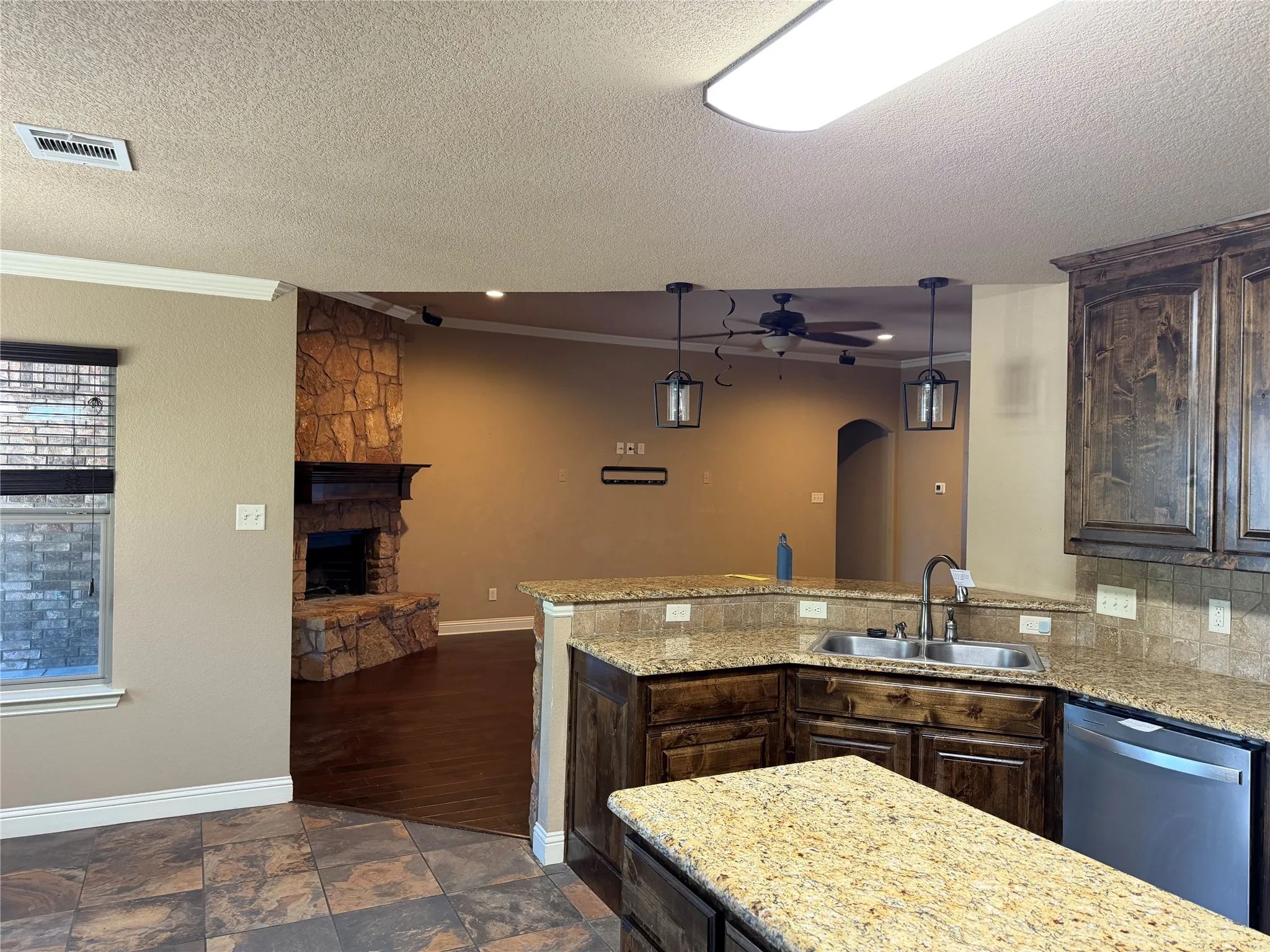 Kitchen featuring granite-look countertops, dark wood cabinetry, and stainless steel appliances
