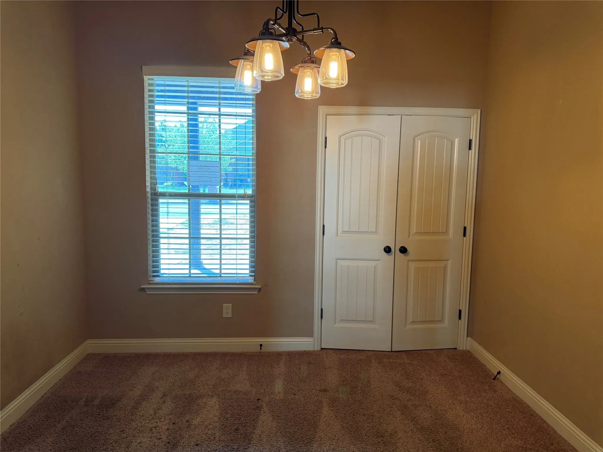 Carpeted flooring paired with a window featuring horizontal blinds