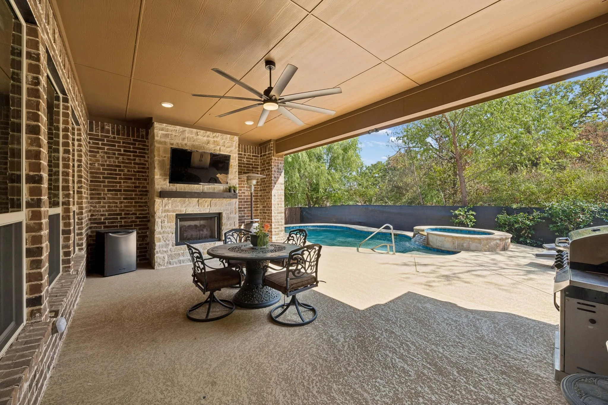 Large, covered patio with fireplace, ceiling fan.