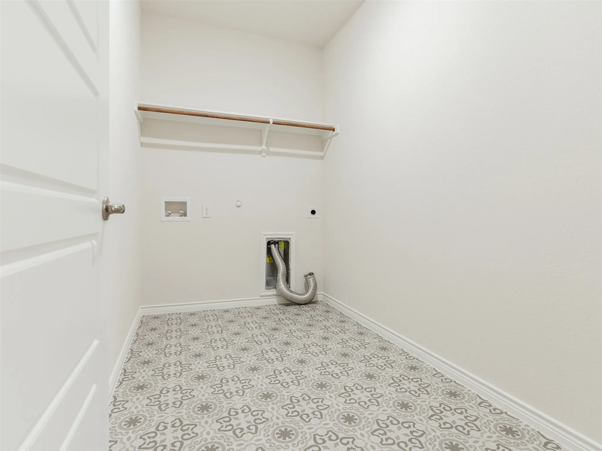 Utility space featuring patterned flooring, crisp white walls, and an overhead clothes rod