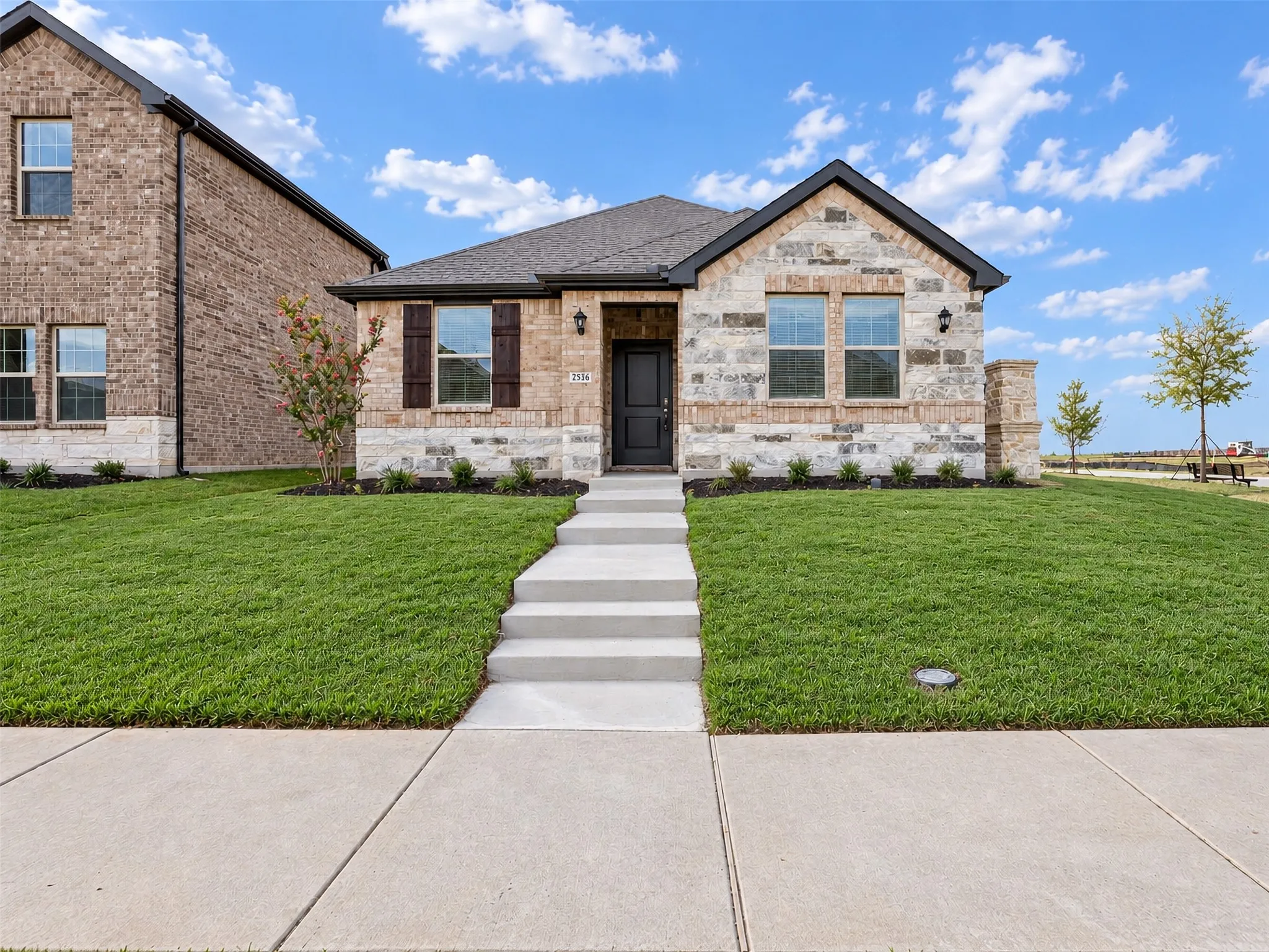 Brick and stone exterior with dark trim and shutters