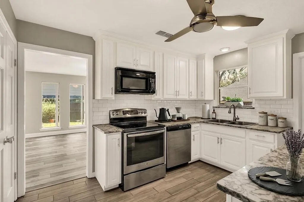 Kitchen featuring white cabinetry, subway tile backsplash, stainless steel appliances, and wood-finish flooring