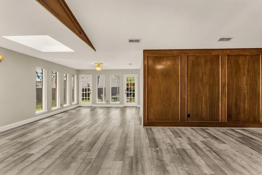 Wood-finish flooring, skylight, exposed wood beam, built-in wood paneling, multiple exterior-facing windows