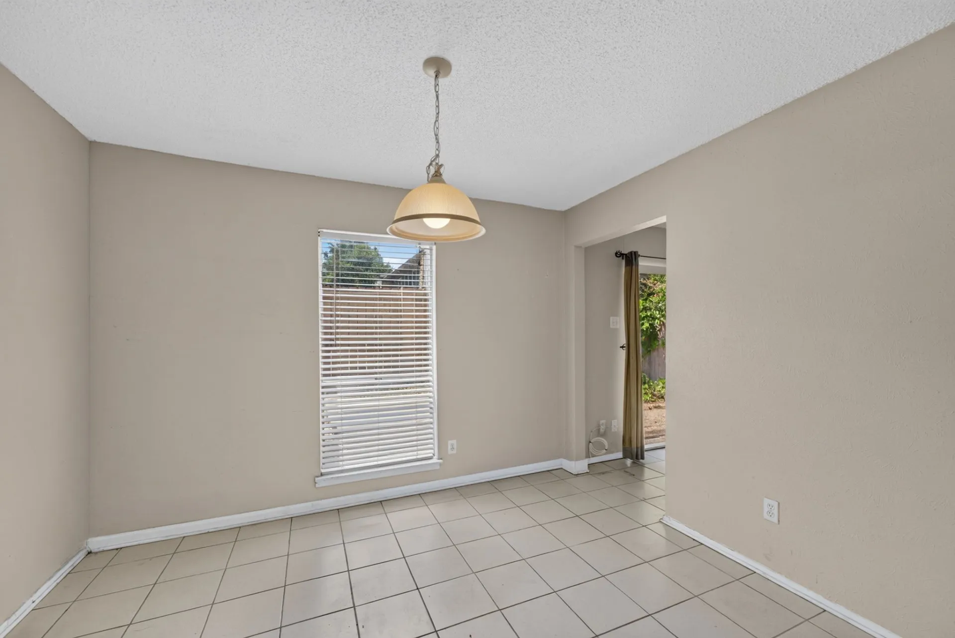 Tiled flooring with a rectangular window, overhead light fixture, and neutral wall tones