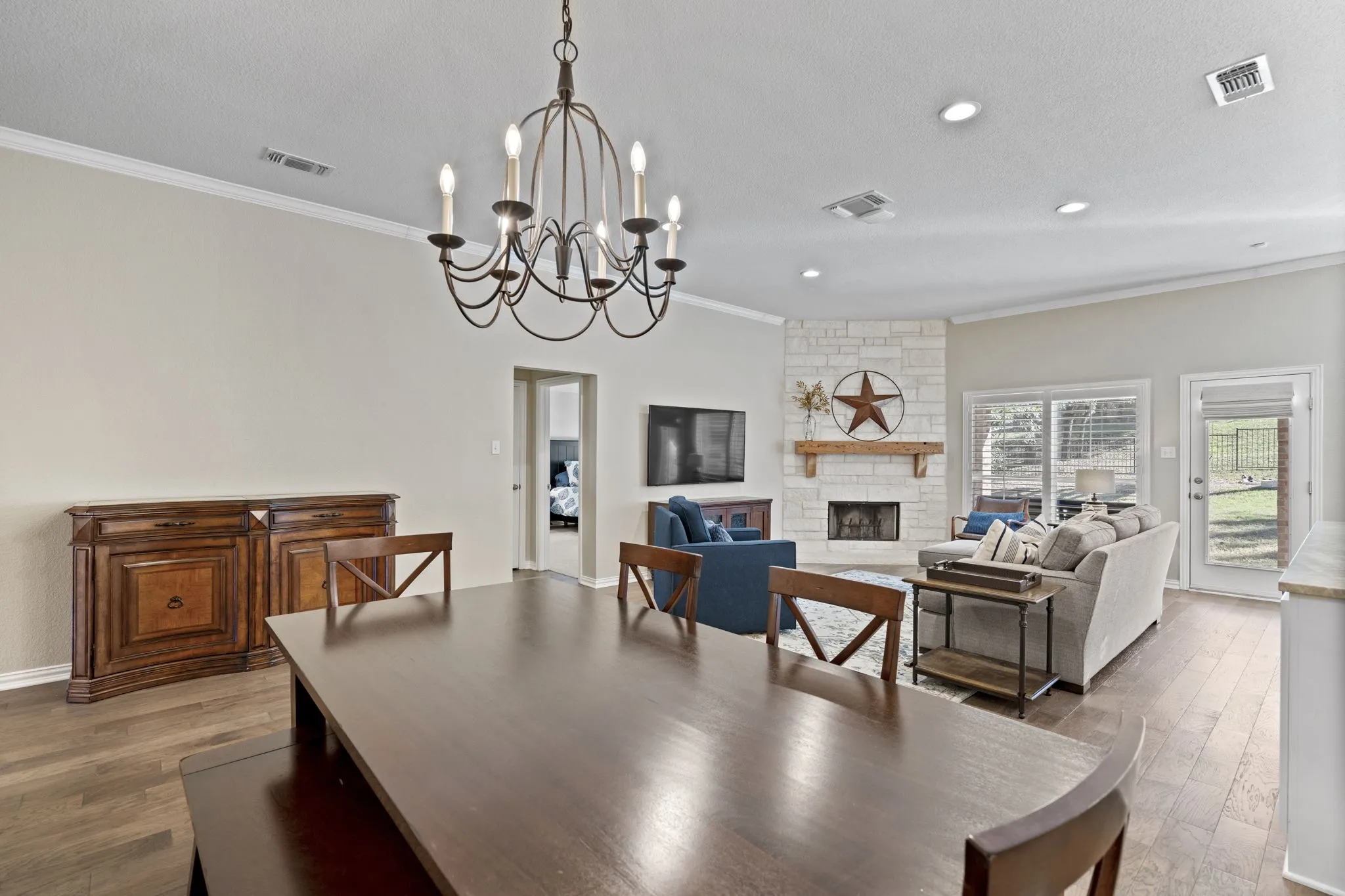 Wood-finish flooring throughout, a chandelier light fixture, and crown molding
