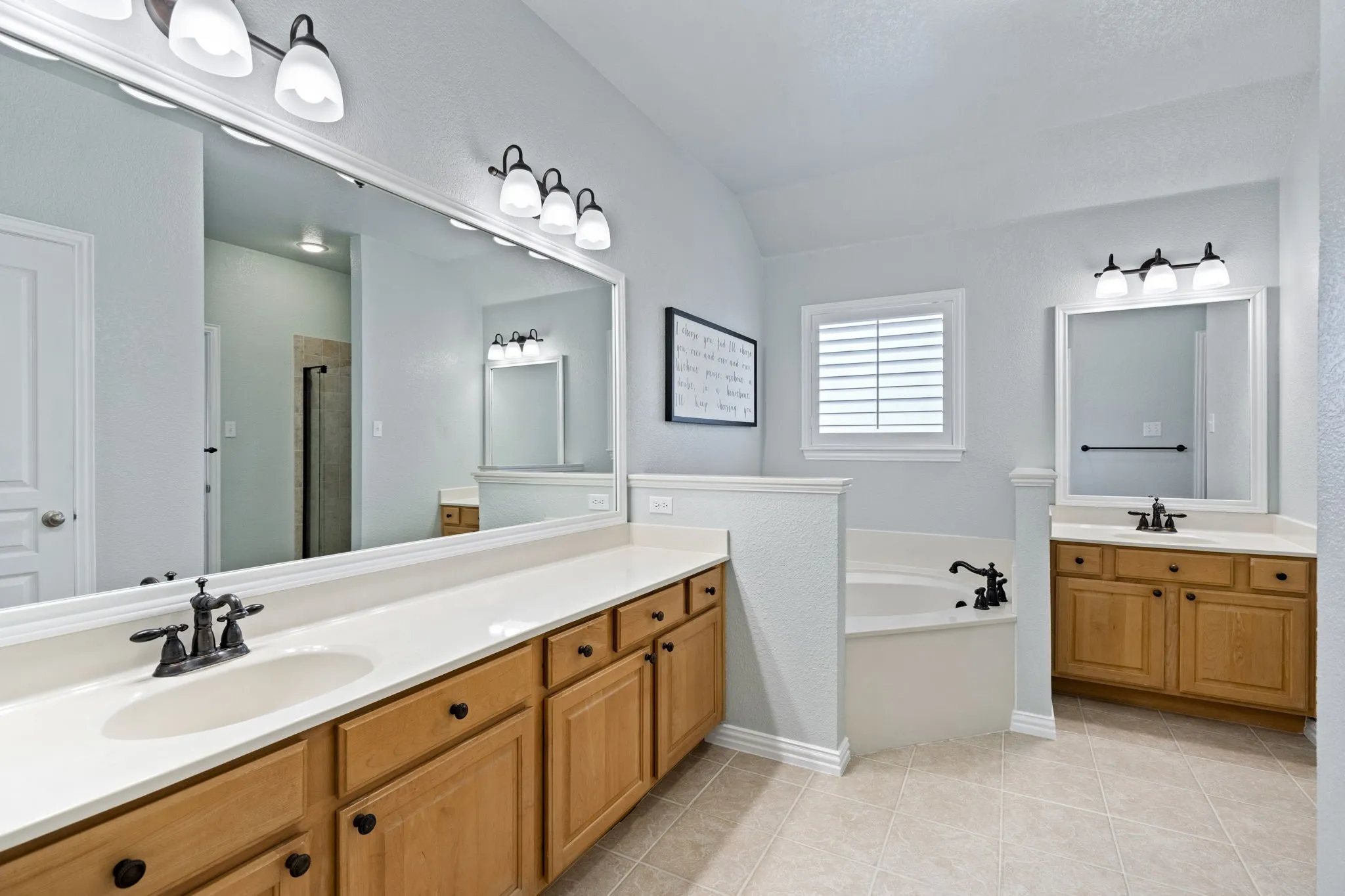 Dual vanities with undermount sinks, wood cabinetry, and extensive countertop space
