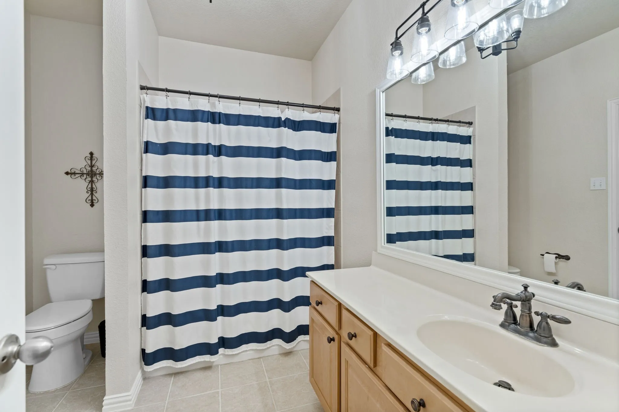 Spacious bathroom with a single vanity, integrated sink, and an expansive wall-mounted mirror