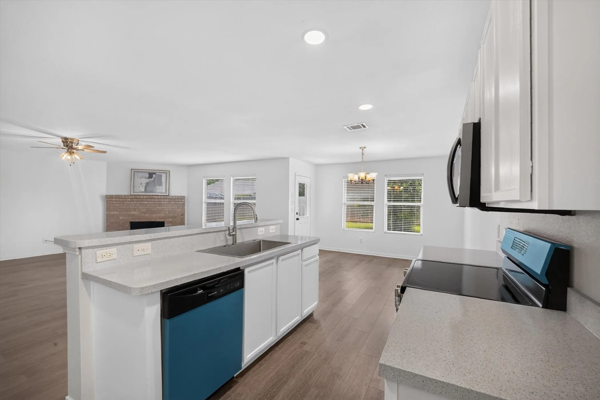 Kitchen island with integrated sink, white cabinetry, and light-colored countertops