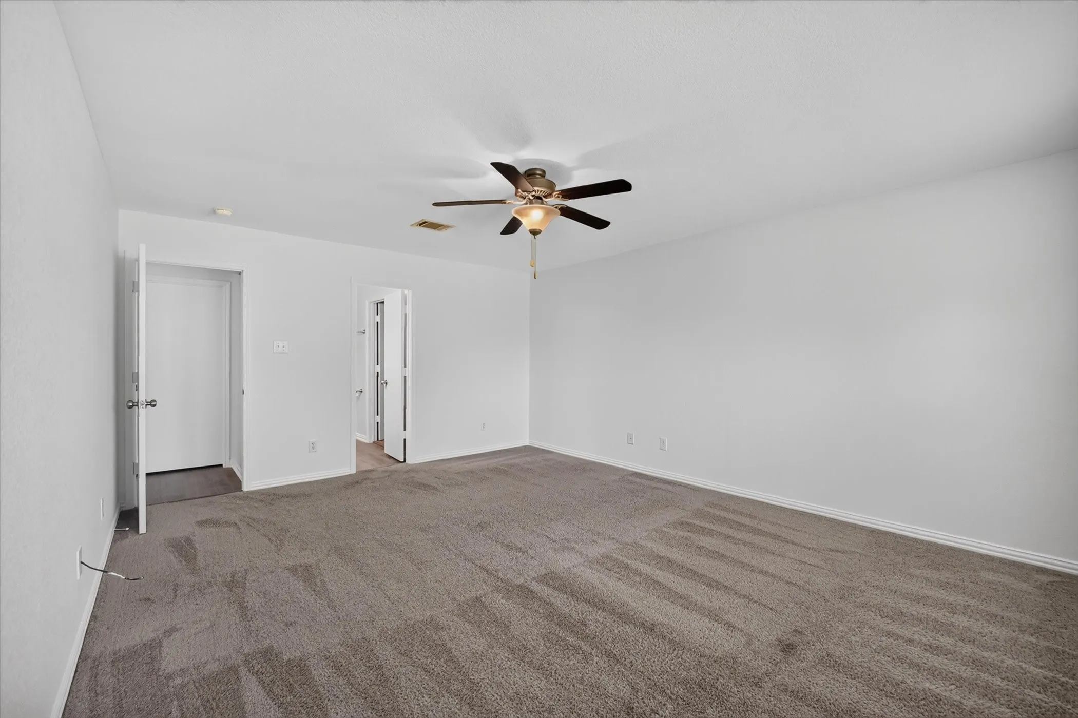 Spacious room with neutral wall tones and plush carpeting