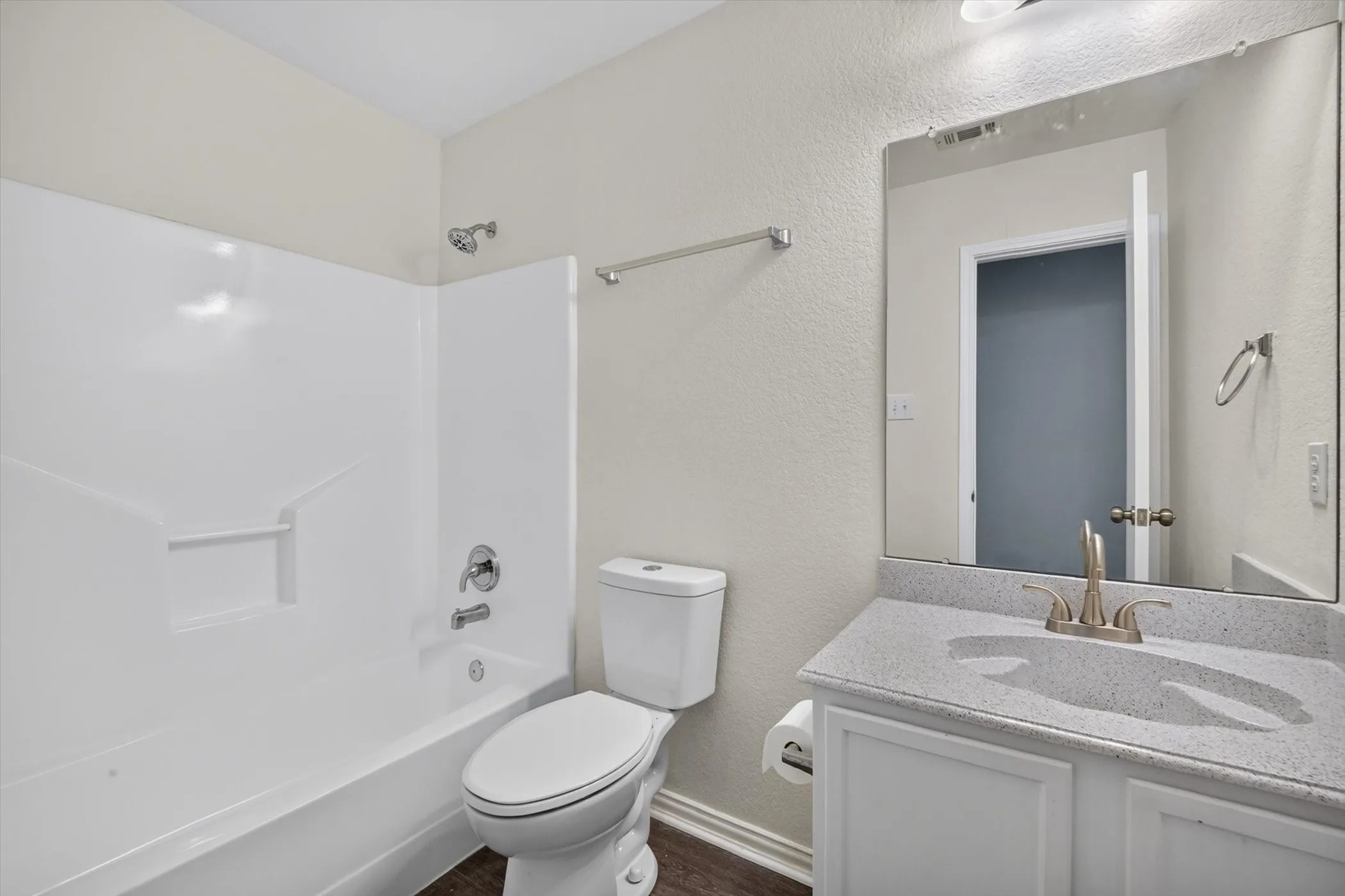 Bathroom featuring a white bathtub, white toilet, and a vanity with a light-colored countertop