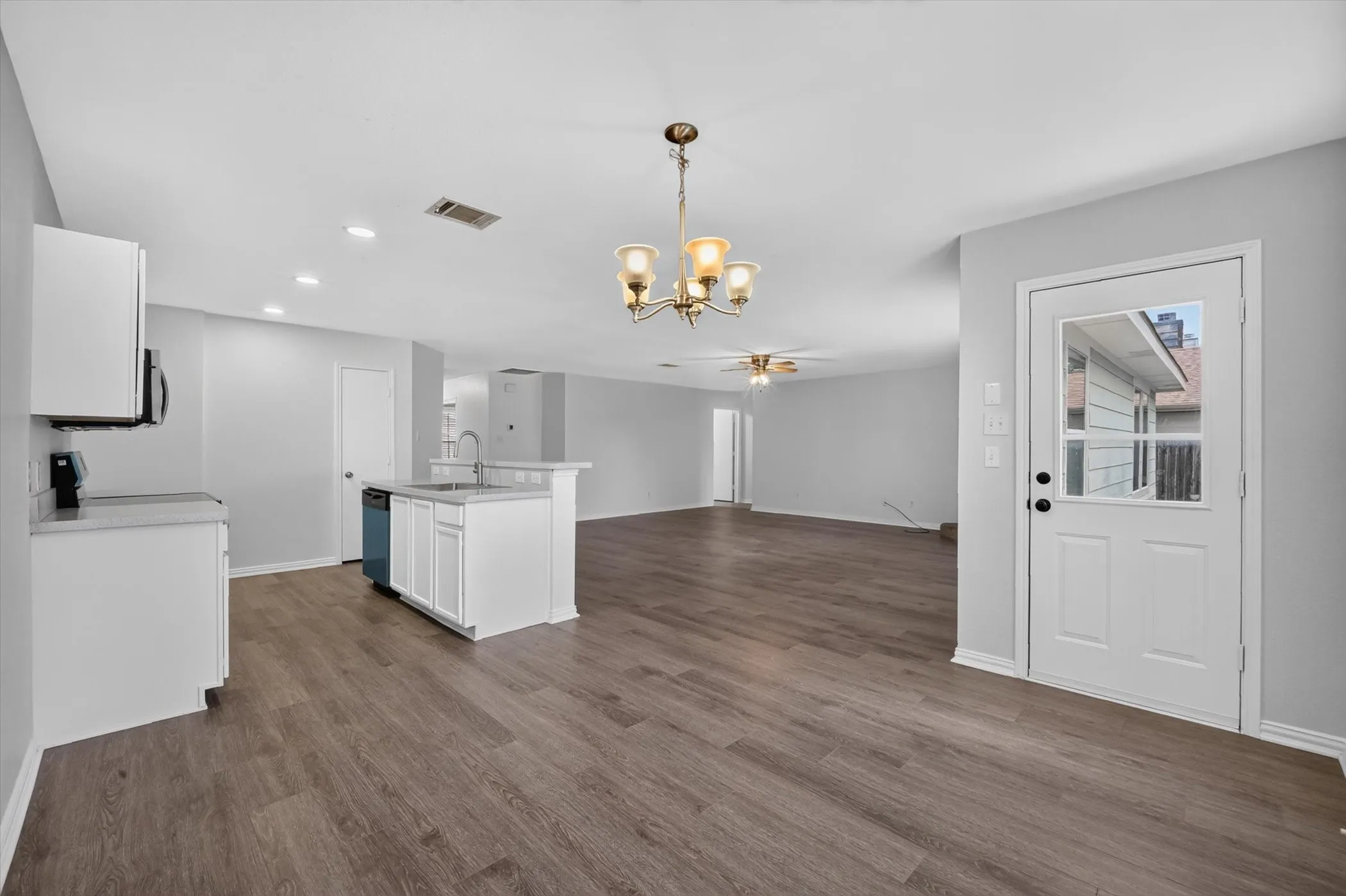 Open-concept living space with wood-finish flooring, recessed lighting, and a neutral color palette