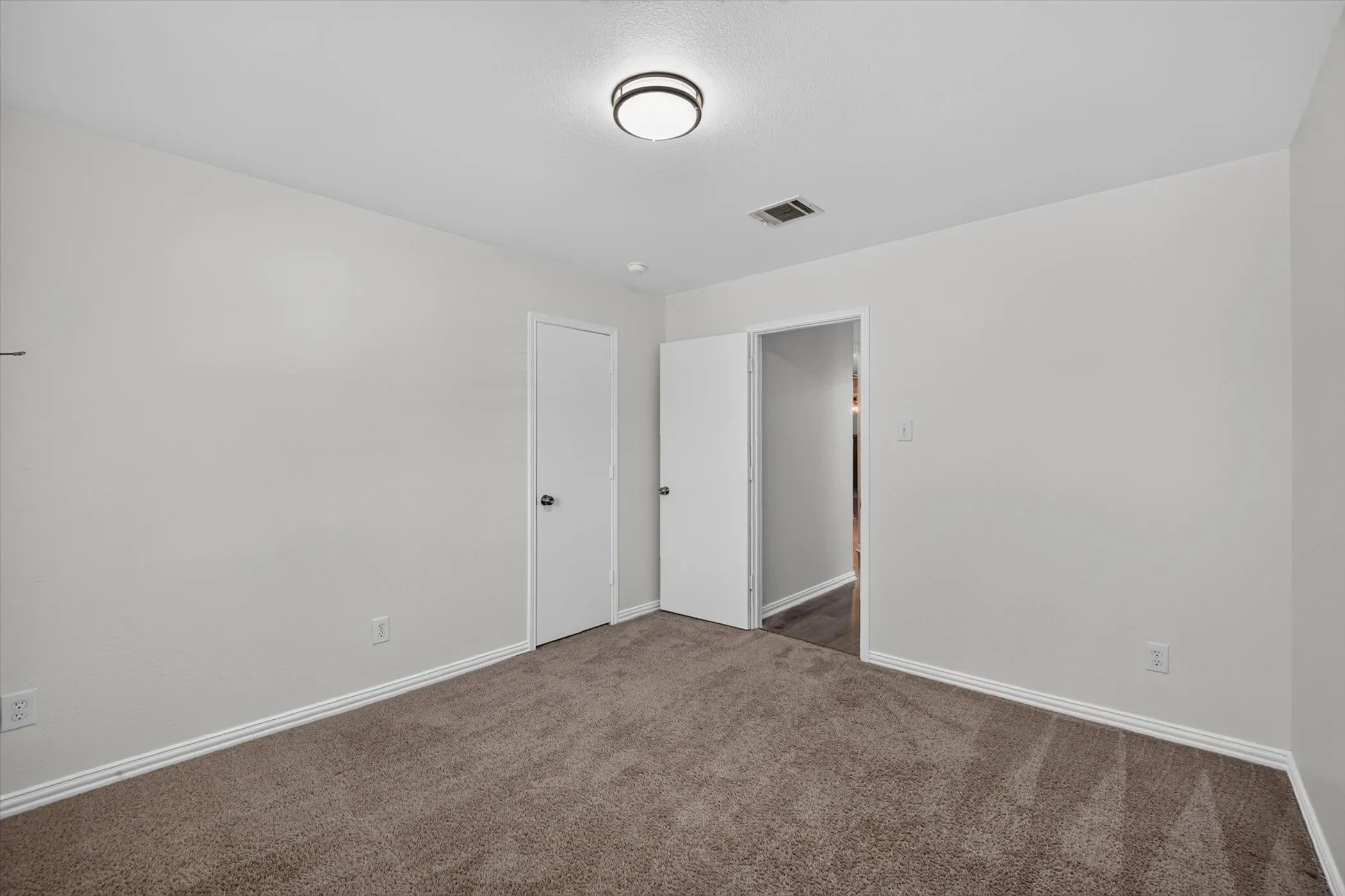 Neutral wall color with brown carpeting