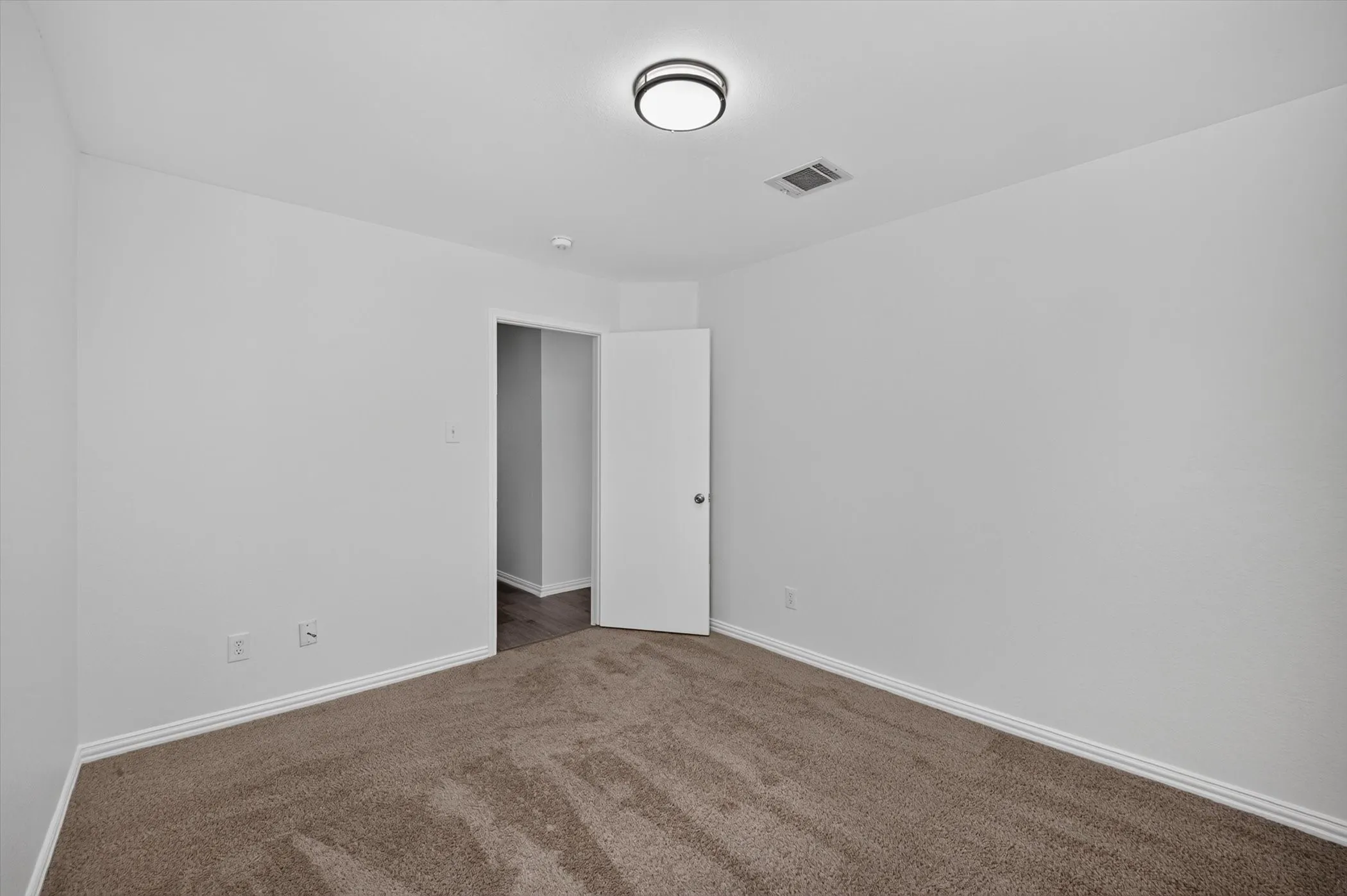 Neutral white walls and plush carpet flooring