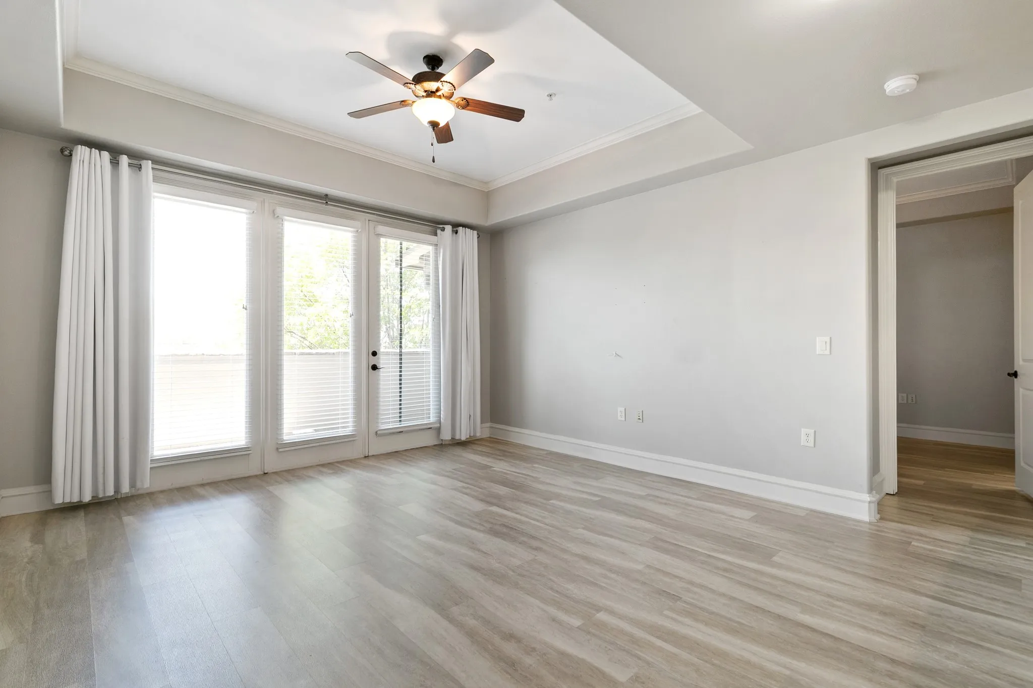 Tray ceiling with a ceiling fan, and white trim molding