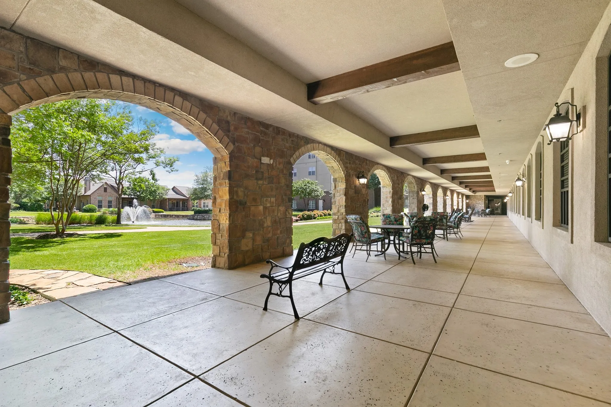 Covered stone archway patio with a large pond and fountain
