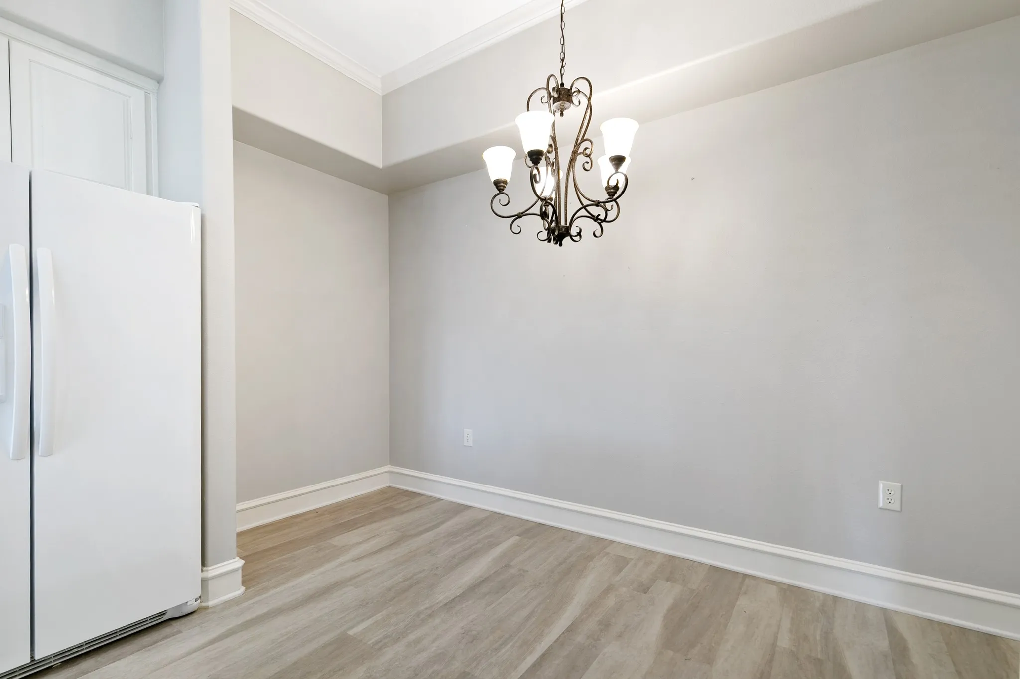 Space for a kitchen table, china cabinets, with a decorative chandelier illuminate this space
