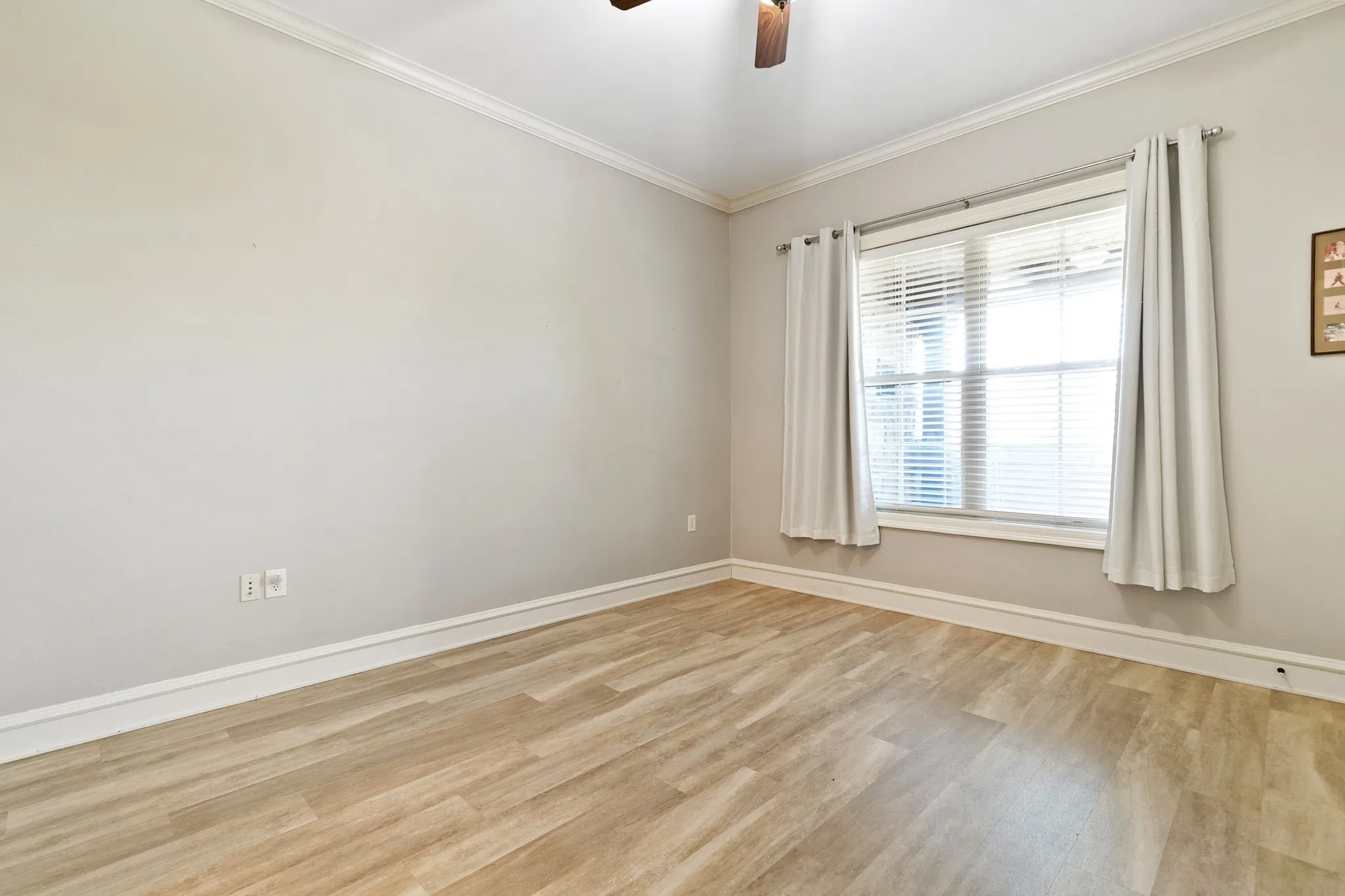 Secondary bedroom with neutral wall color, crown molding, double window, and ceiling fan