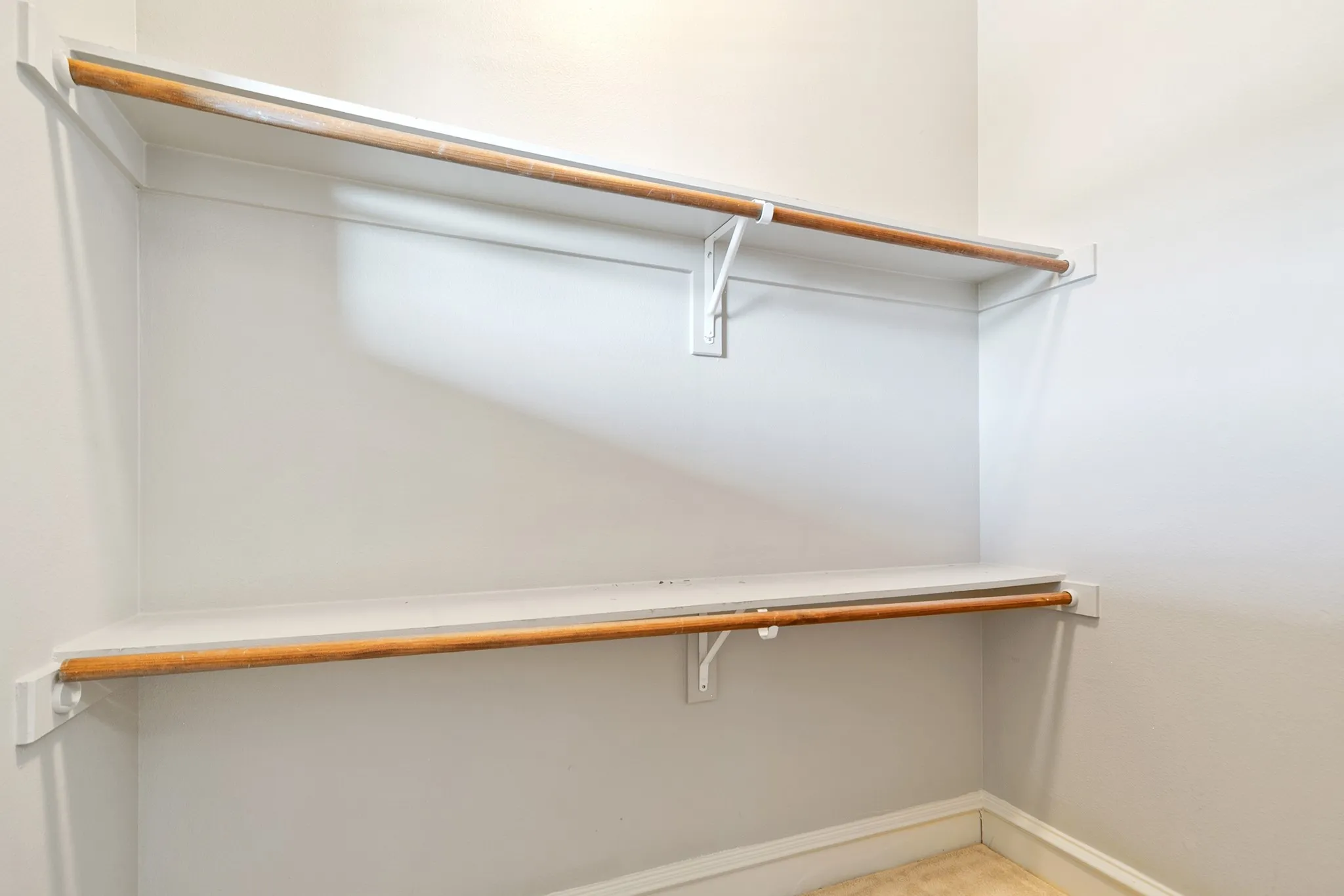 Built-in shelving and hanging rods with white wall finishes