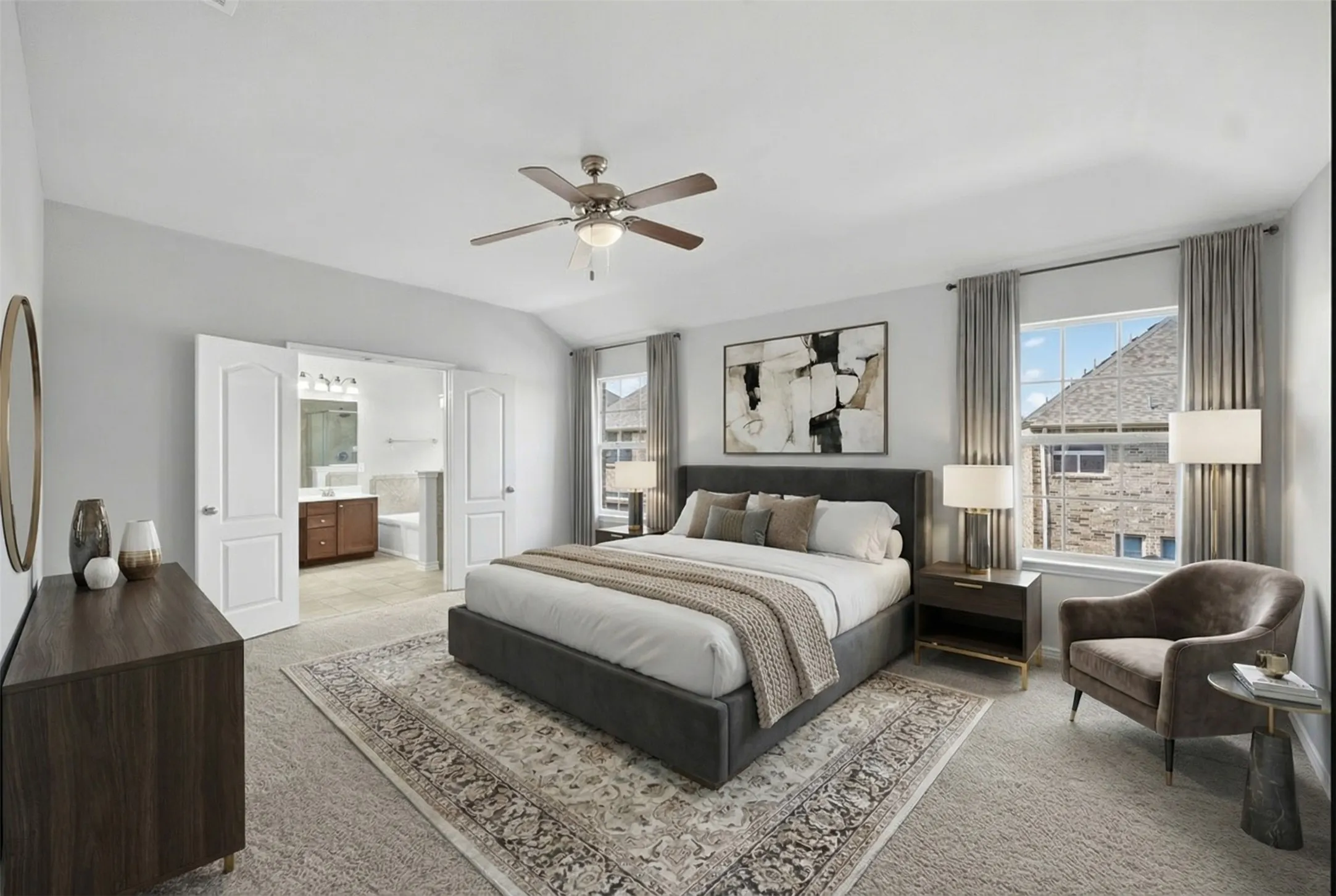 Vaulted ceiling with ceiling fan, dual windows with curtain rods, and interior double doors opening to a bathroom