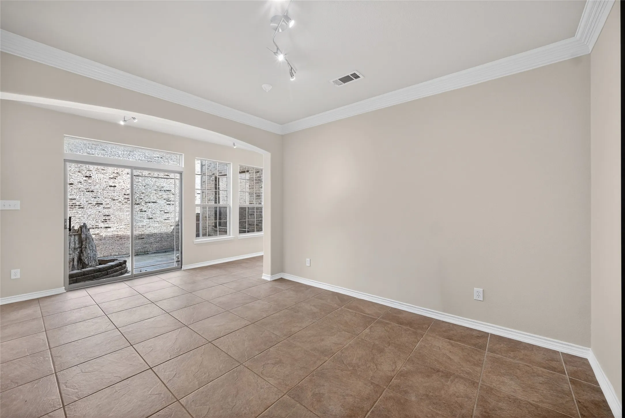 Tile flooring, crown molding, arched entryways, sliding glass patio door, and recessed lighting