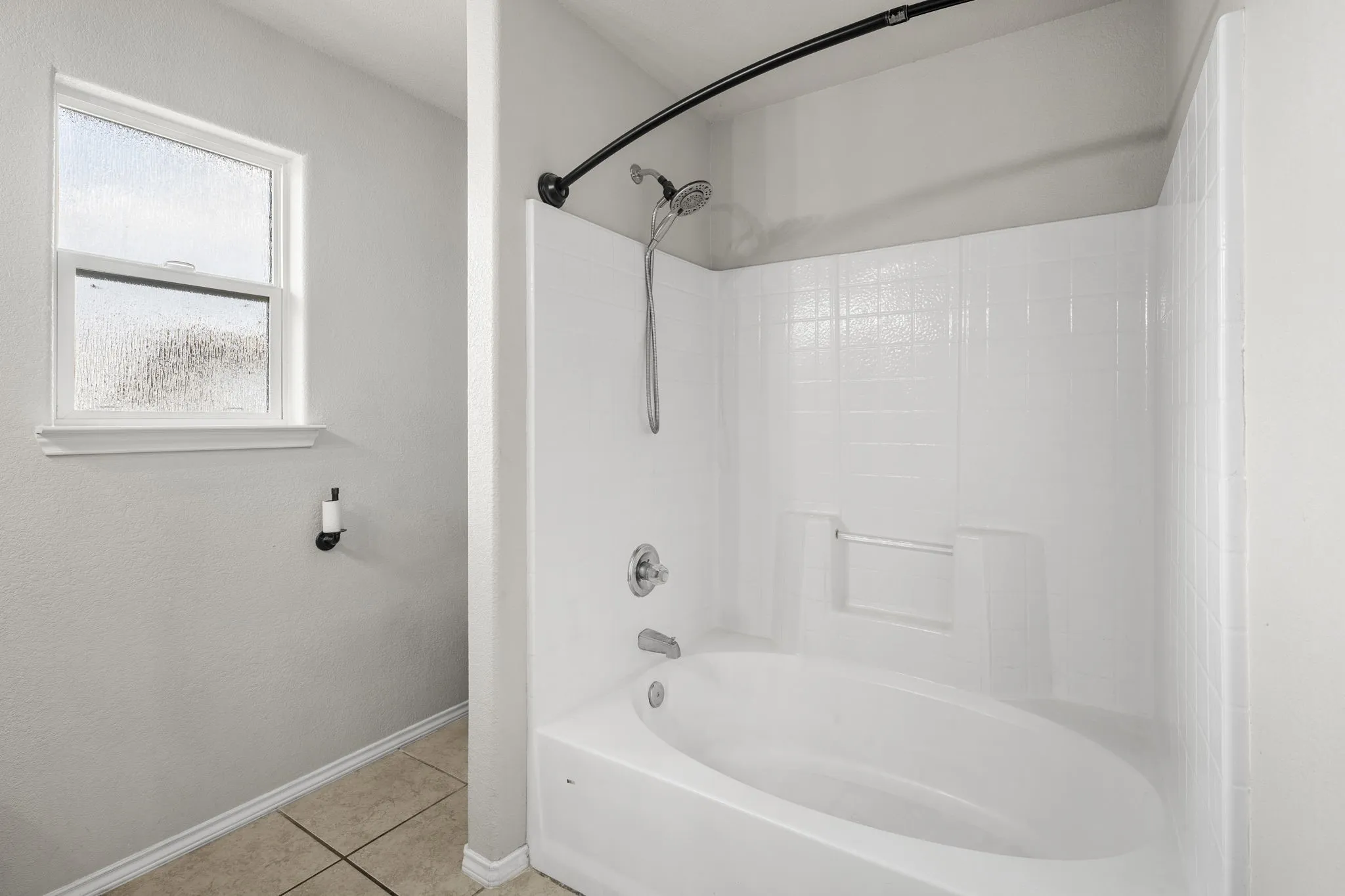 White acrylic tub and shower combination with a curved shower rod