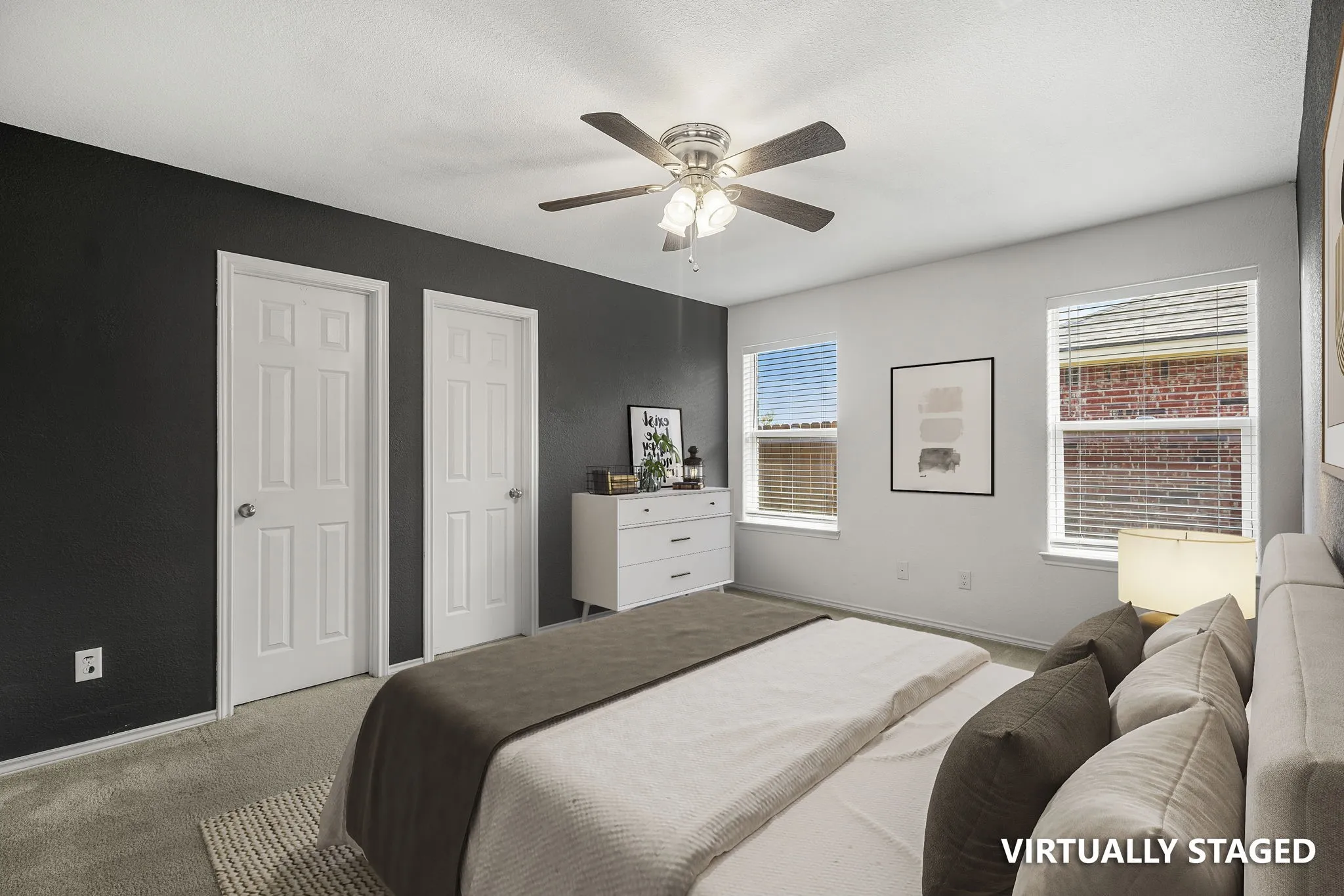 Room featuring dual windows, ceiling fan with integrated lighting, and carpeted flooring