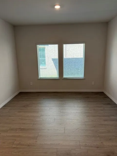 Recessed ceiling lighting, wood-finish flooring, and two window openings