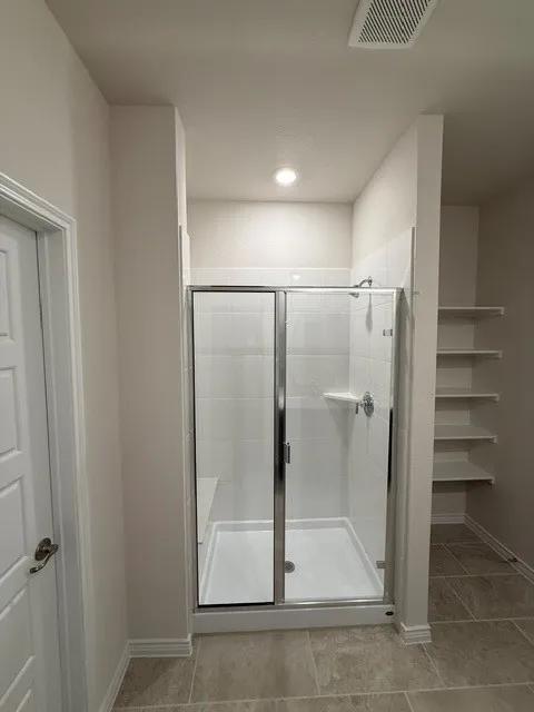 Walk-in shower with clear glass enclosure and integrated bench seating
