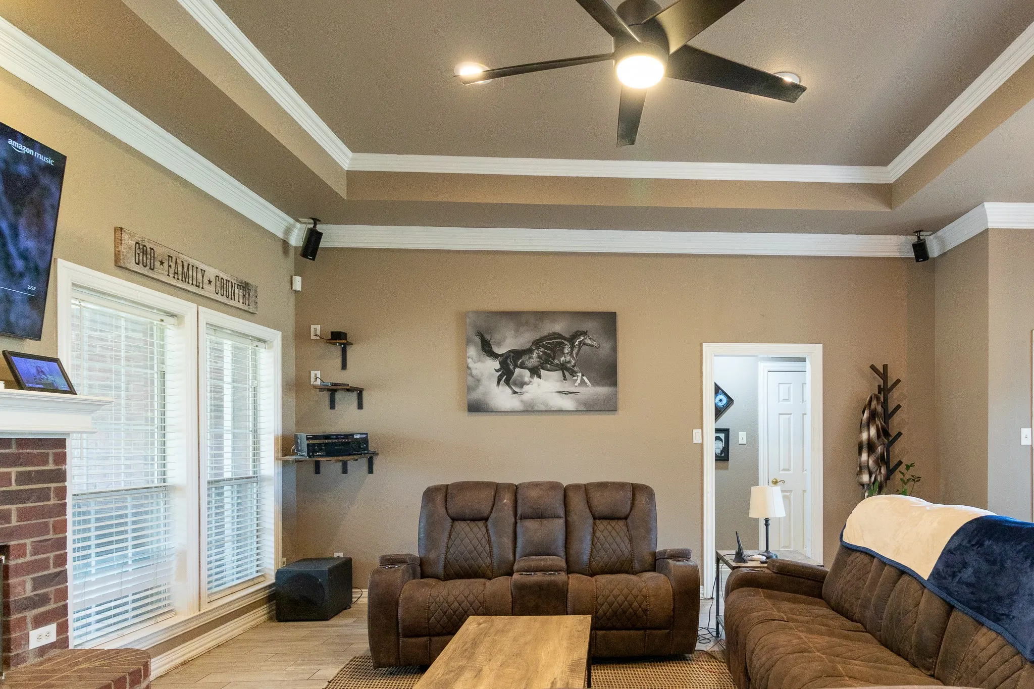 Living space featuring a tray ceiling with crown molding, recessed lighting, and a ceiling fan