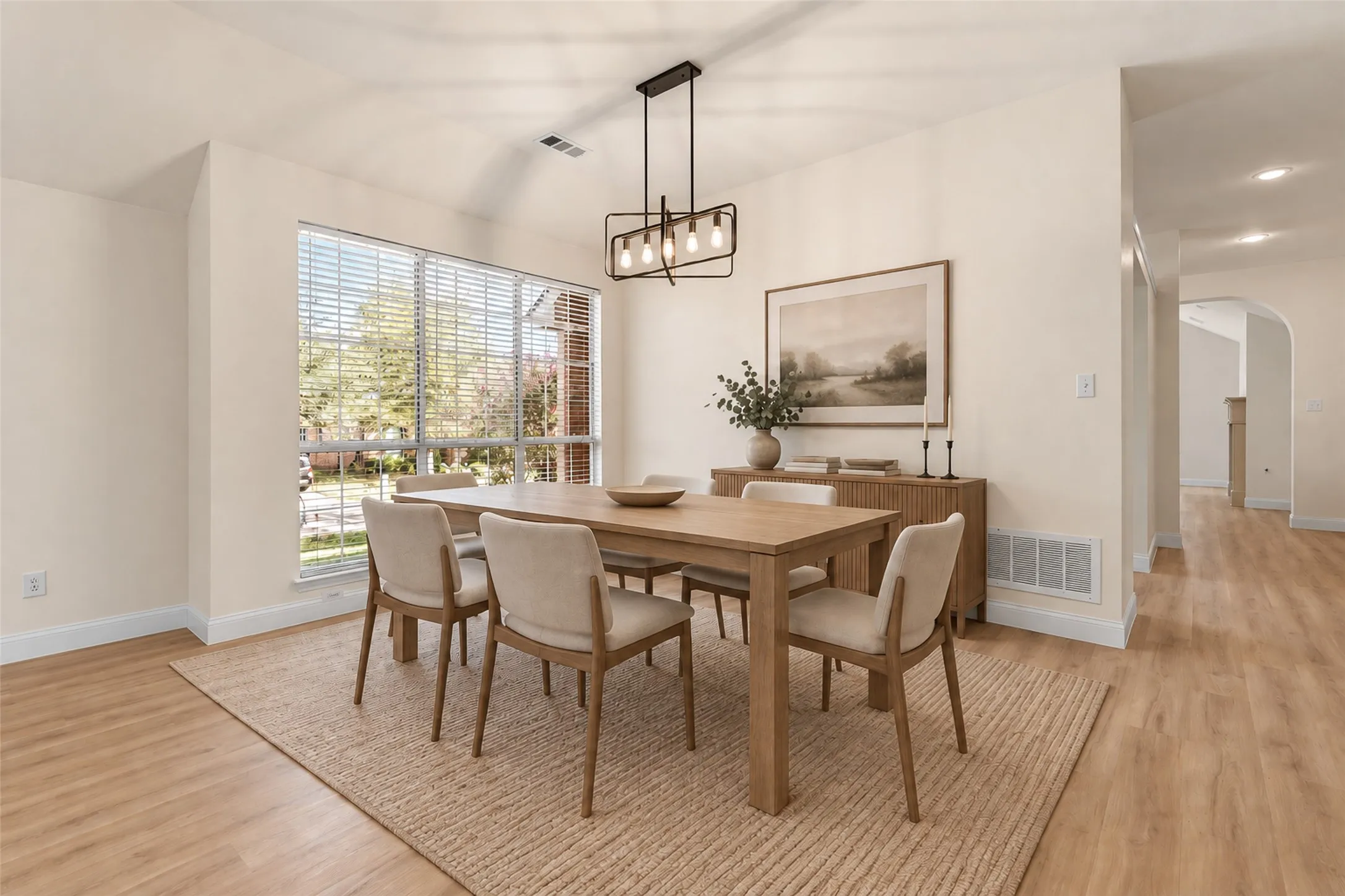 Virtually staged
Window with blinds, wood-finish flooring, vaulted ceiling, recessed lighting, and an arched hallway entry