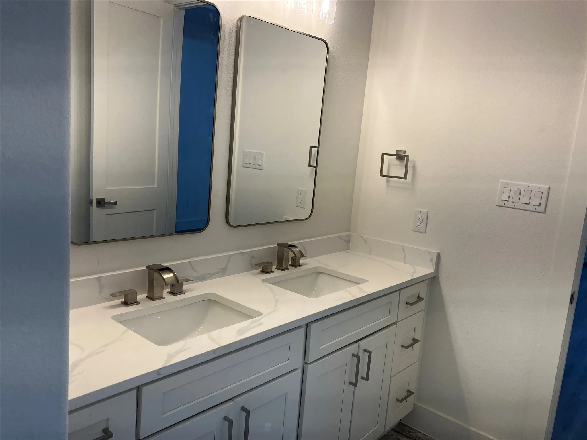 Dual vanity with integrated sinks, white cabinetry, and brushed nickel hardware
