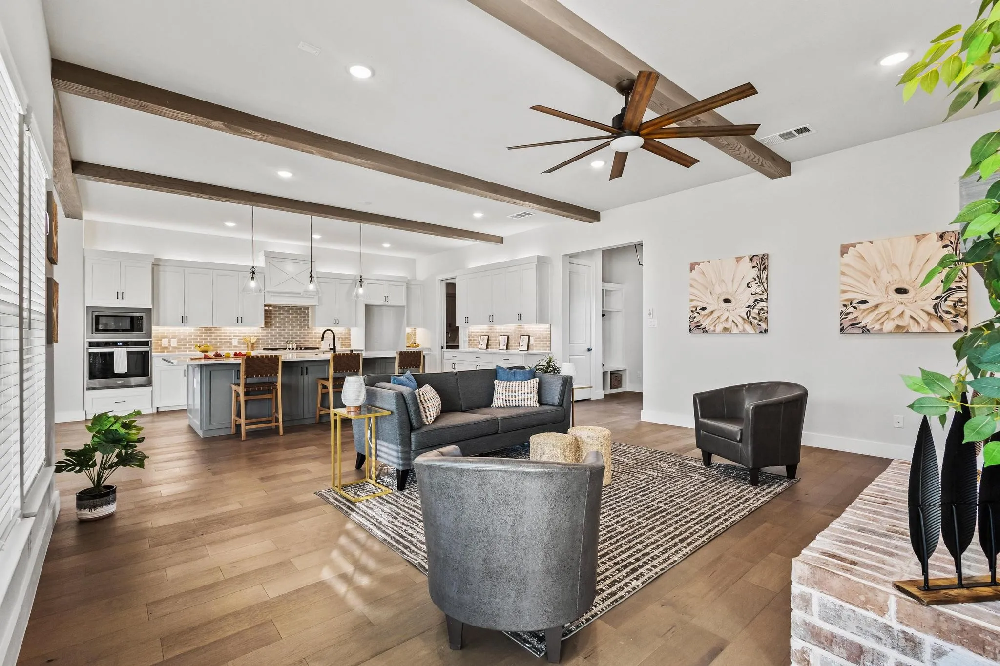 Living room featuring beam ceiling, ceiling fan, light wood-style floors, and recessed lighting