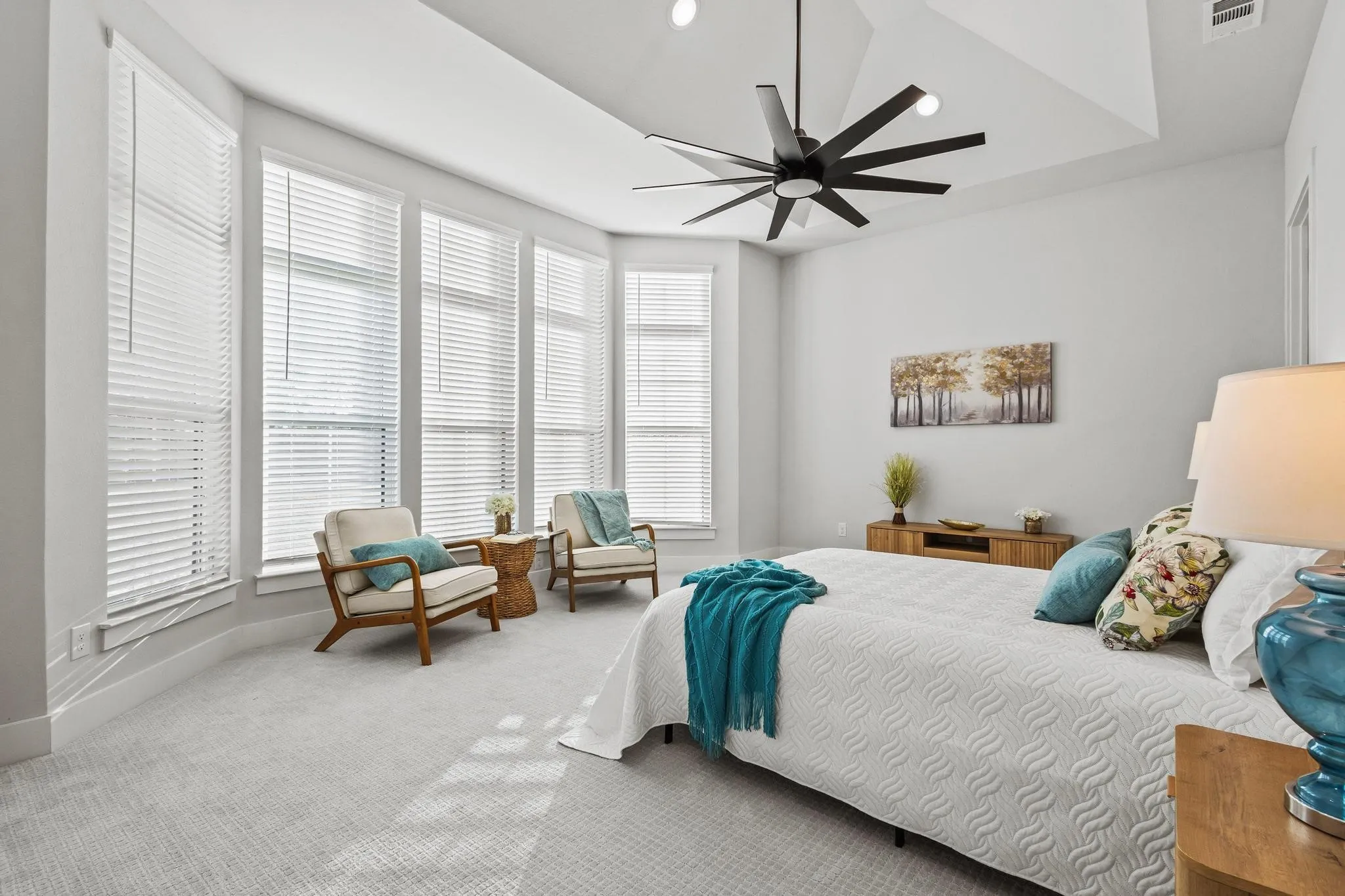 Carpeted bedroom with recessed lighting, ceiling fan, and a raised ceiling