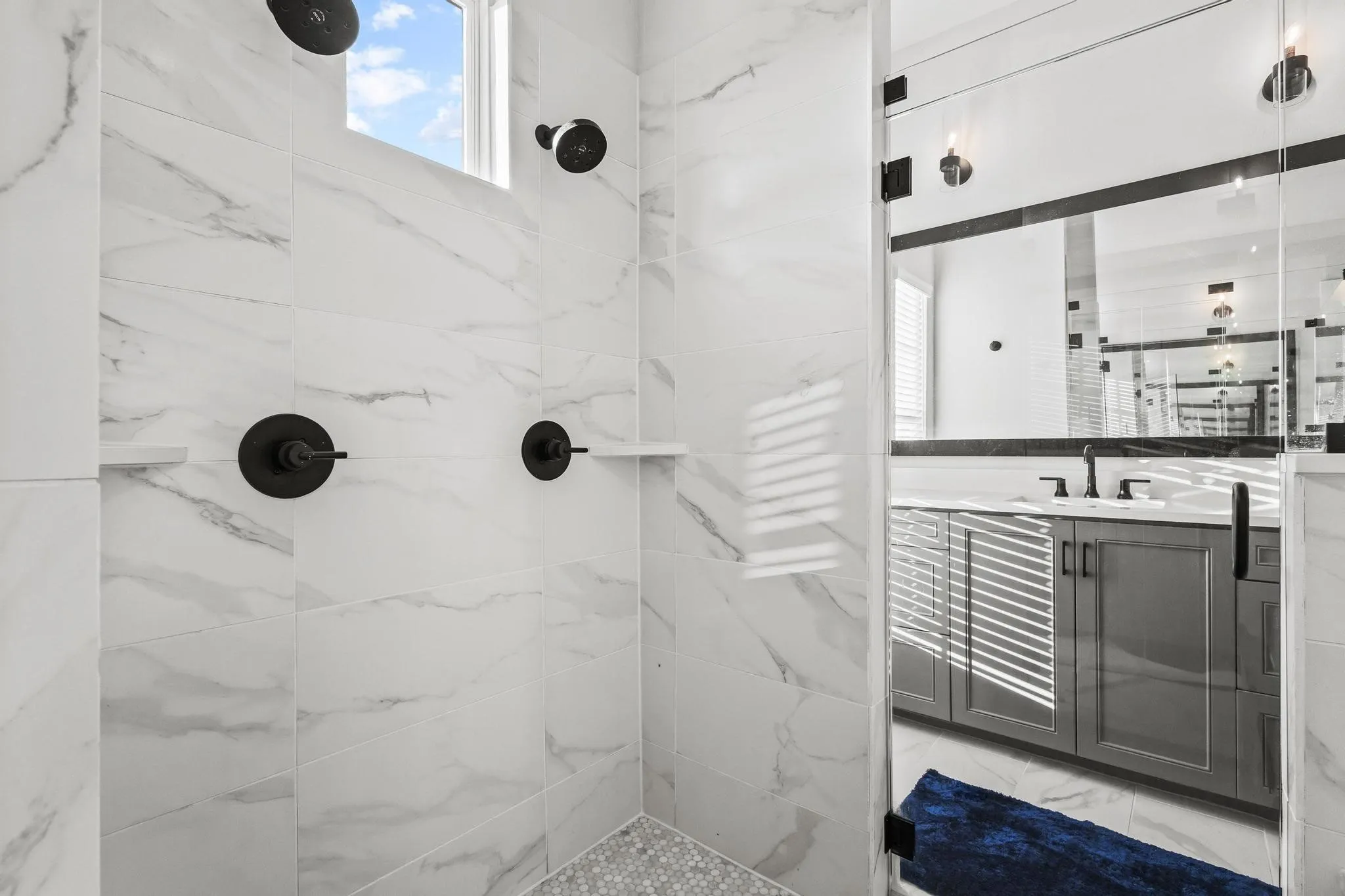 Bathroom featuring a marble finish shower and vanity