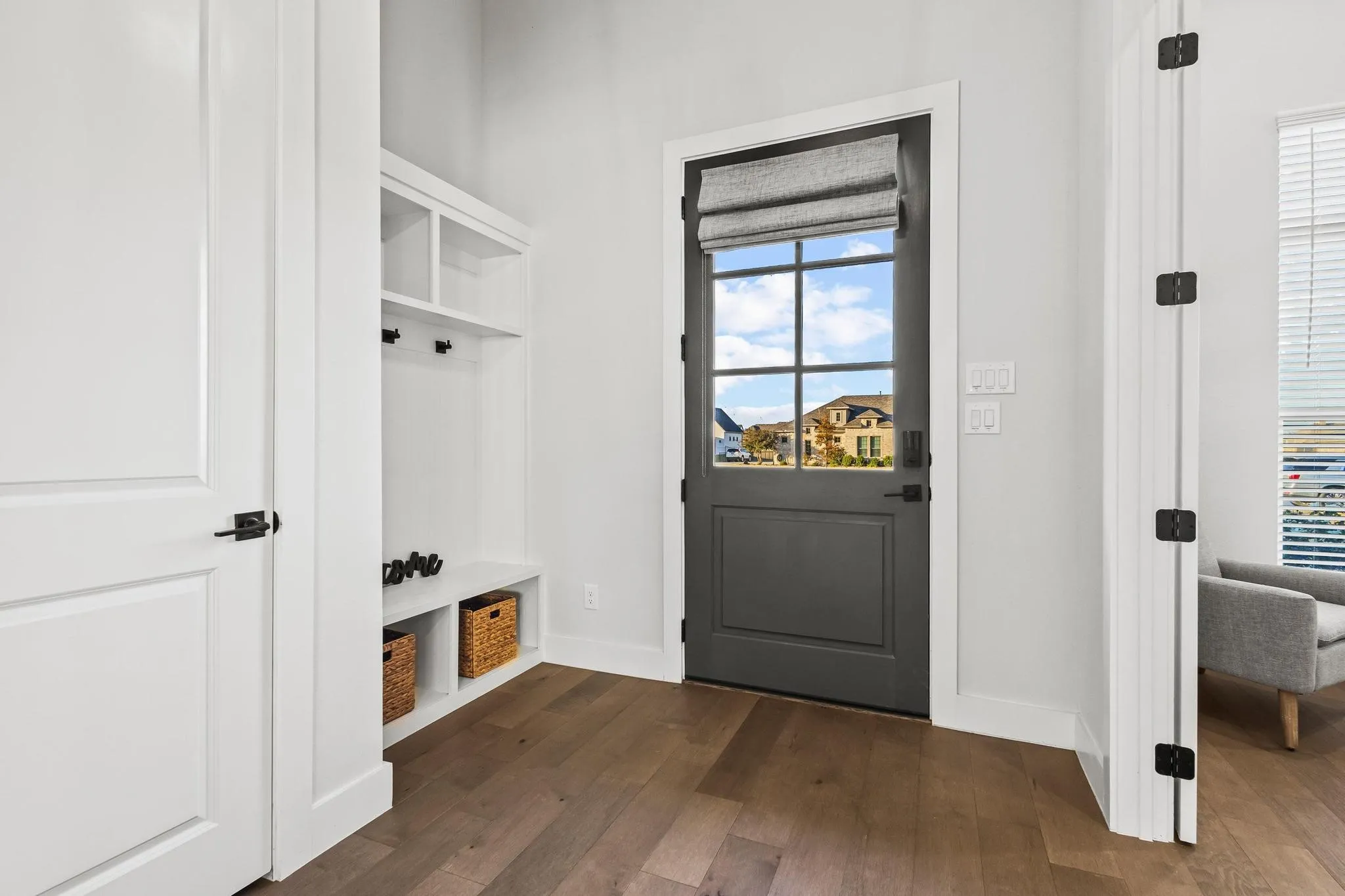 Mudroom featuring dark wood-style flooring and baseboards