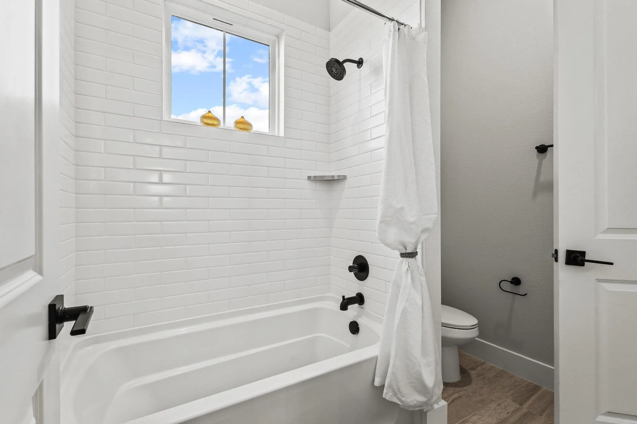 Jack and Jill Bathroom with shower / bath combo and wood finished floors