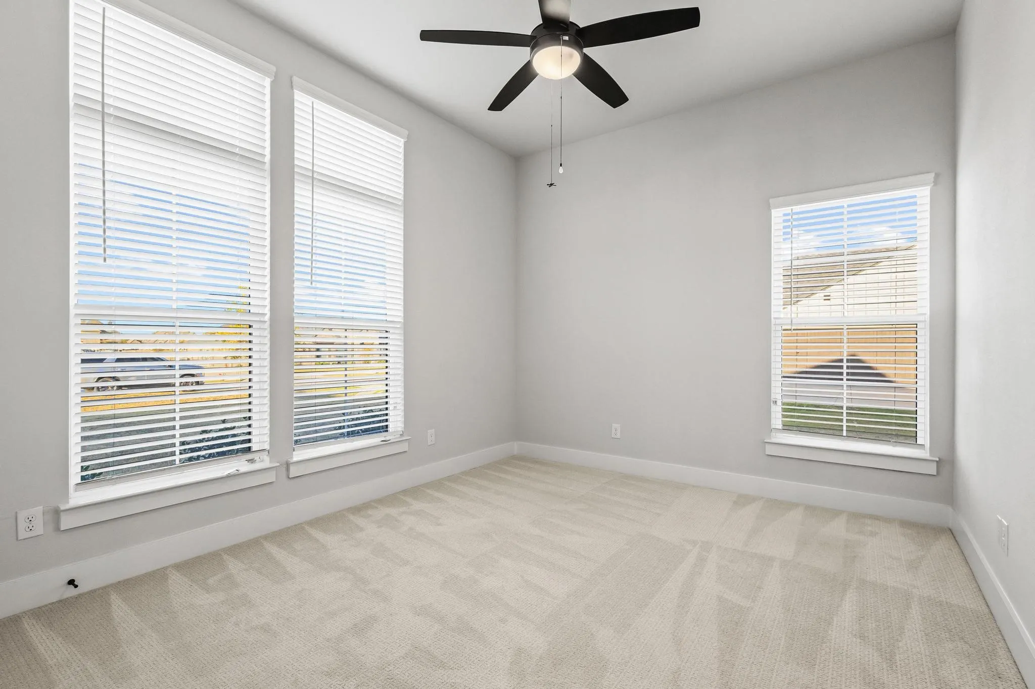 Unfurnished room featuring light carpet and a ceiling fan