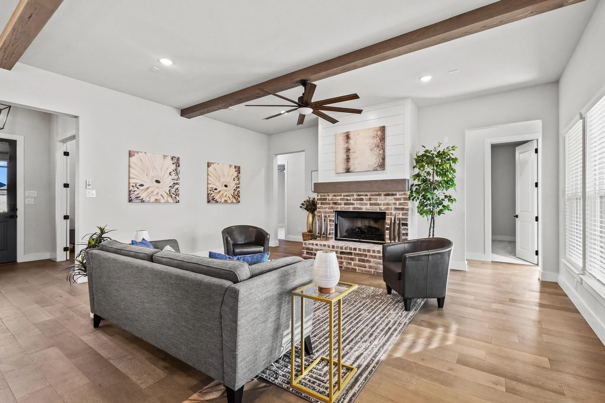 Living area with beam ceiling, a ceiling fan, gas fireplace, plenty of natural light, light wood-style floors, and recessed lighting