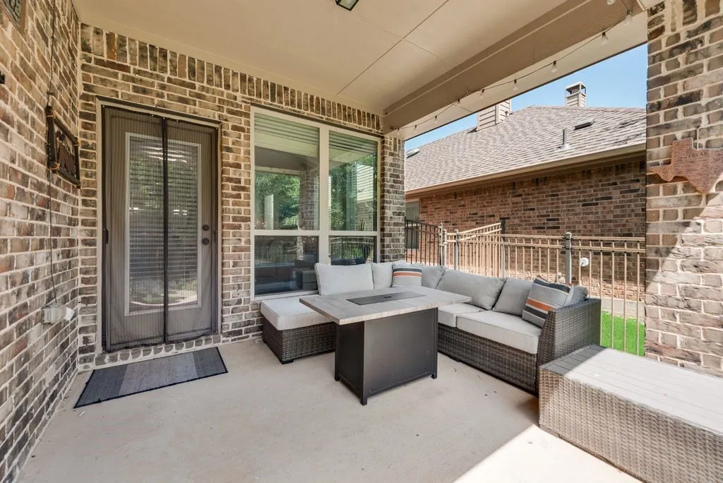Covered patio featuring brick exterior walls and concrete flooring