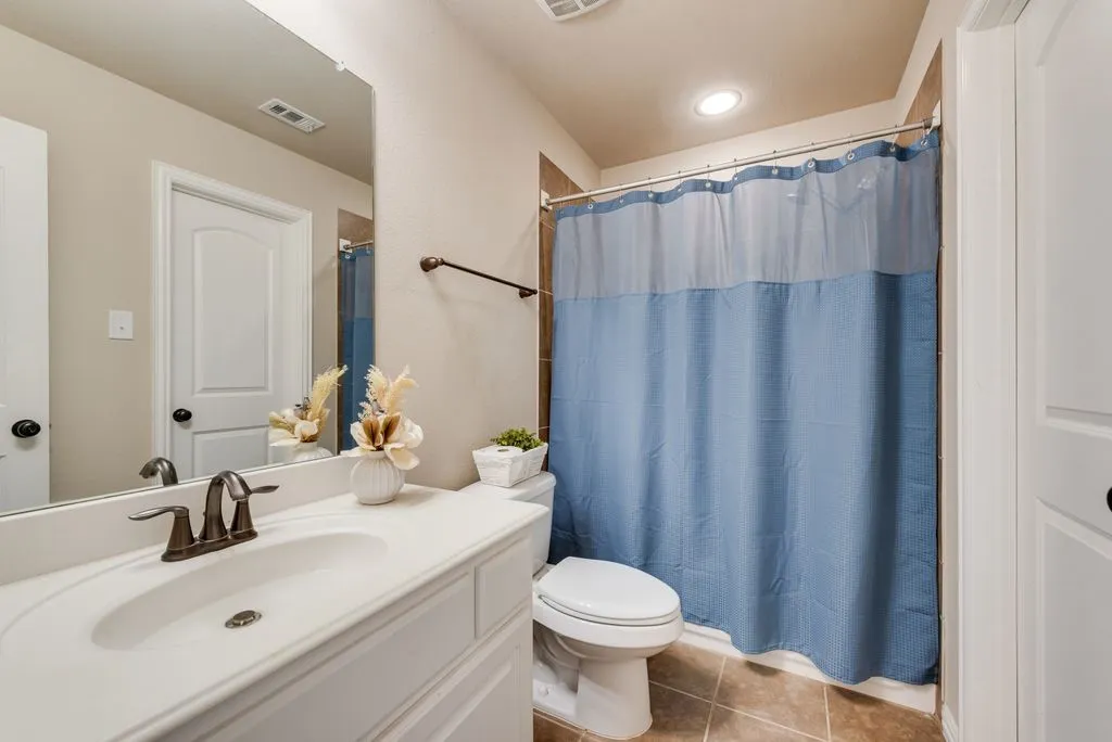White vanity with integrated sink, bronze-finish faucet, and a large wall-mounted mirror