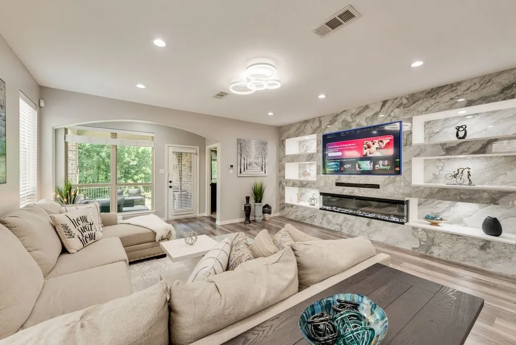 Integrated entertainment wall with built-in fireplace and illuminated display niches