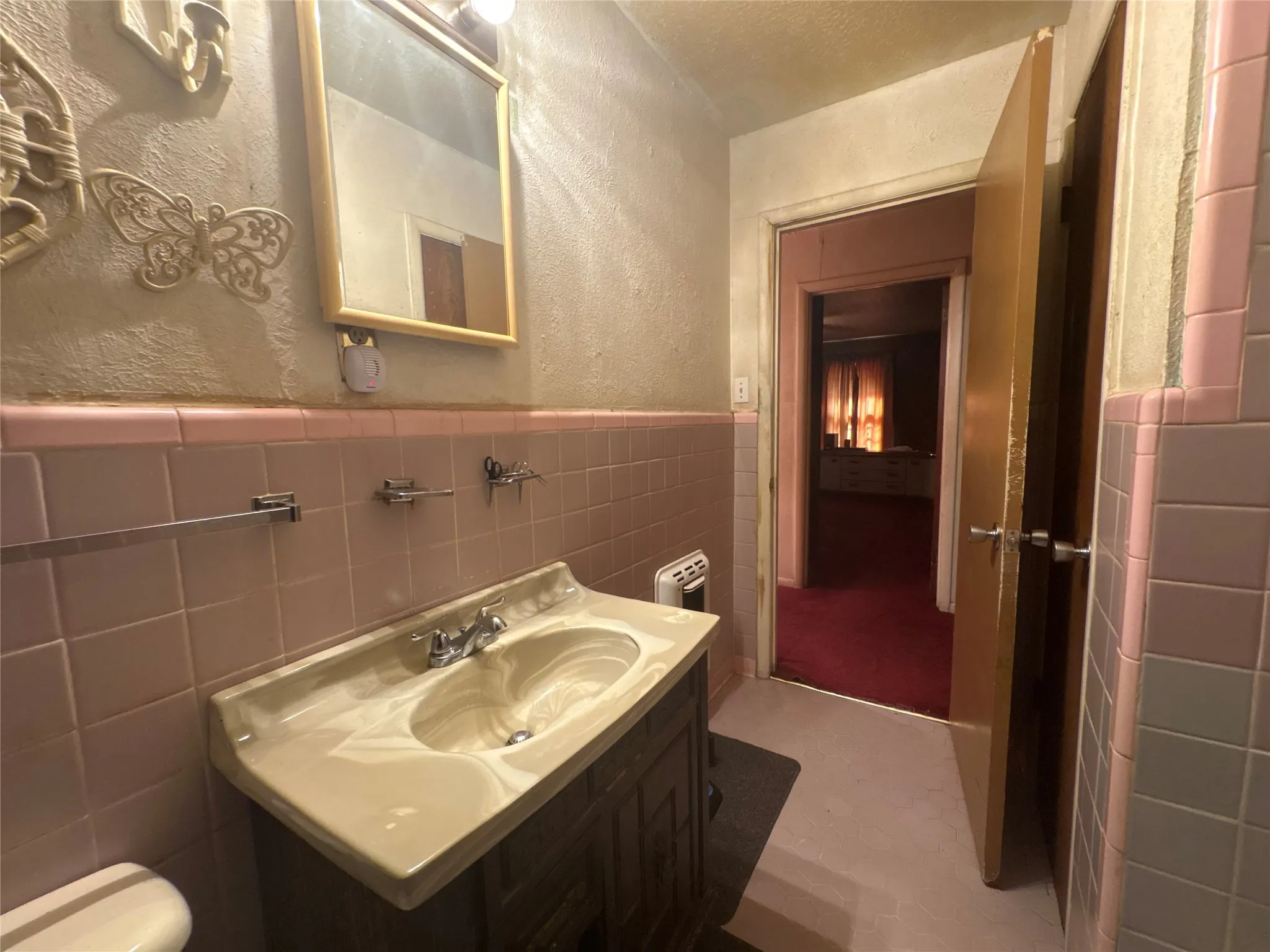 Wall-mounted vanity with integrated sink, chrome faucet, and wood-finish cabinetry
