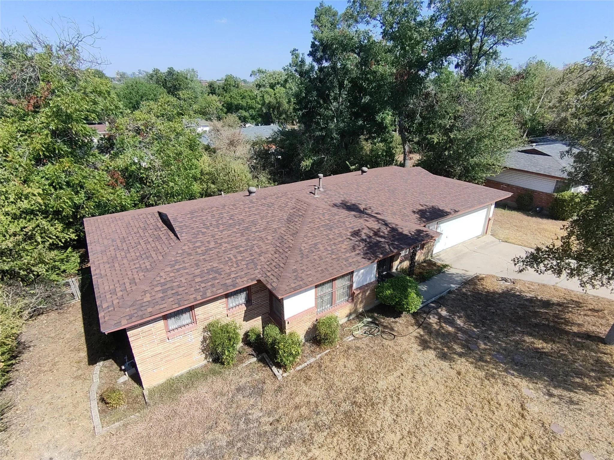 Brown shingle roof with a brick and siding exterior