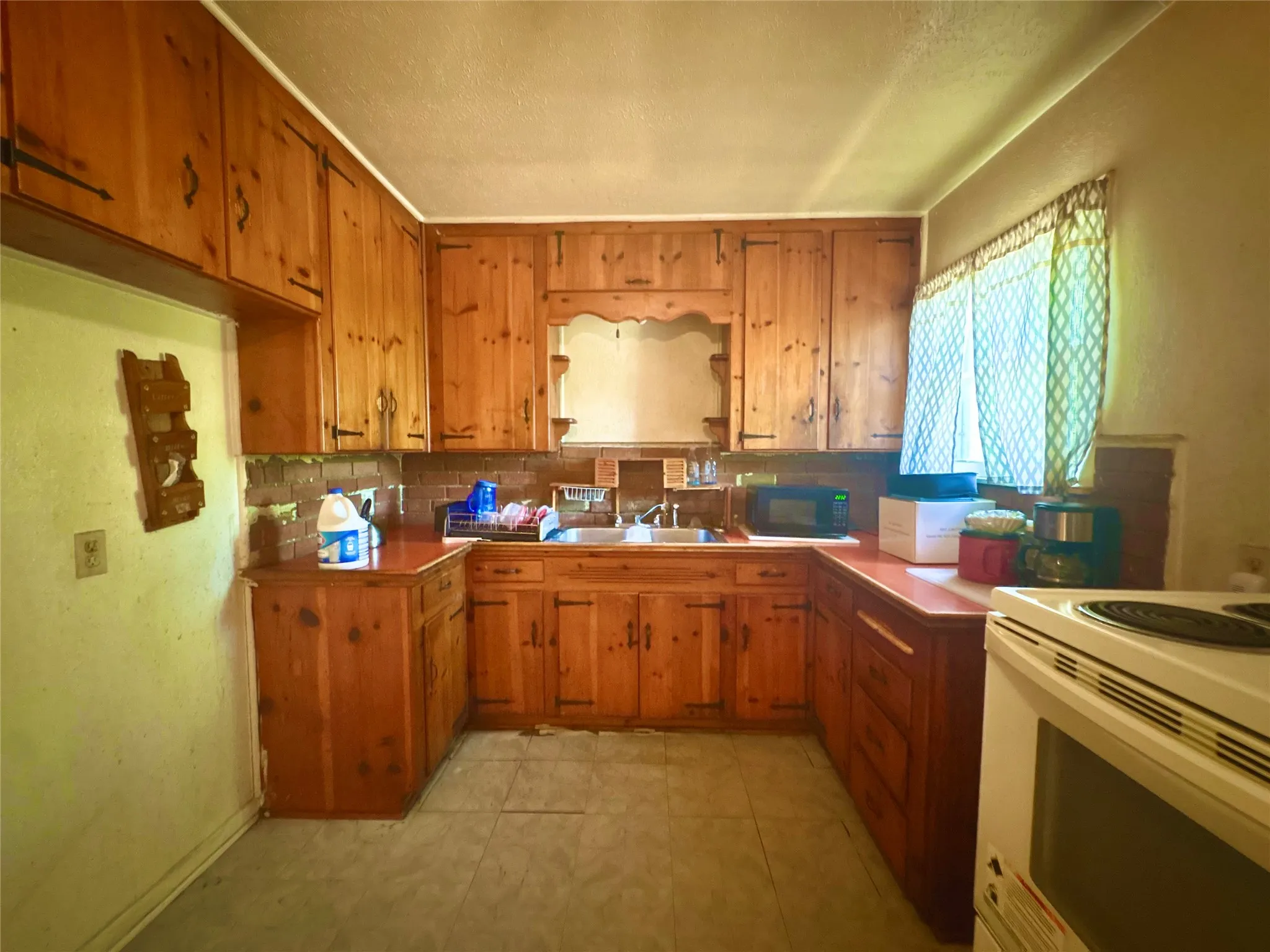 Kitchen featuring wood cabinetry, a built-in sink, and a tiled backsplash