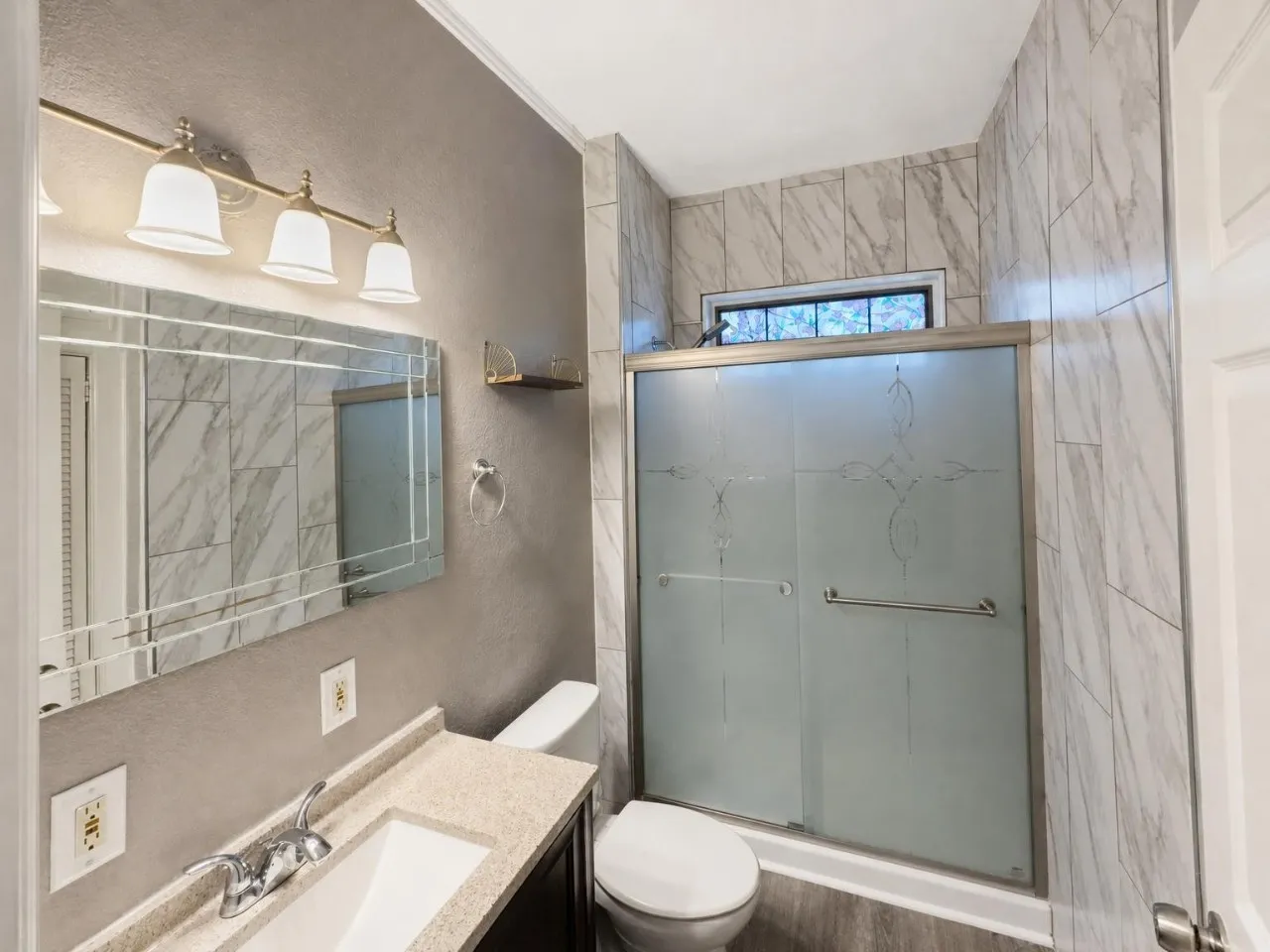 Vanity with integrated sink, decorative mirror, and three-light fixture