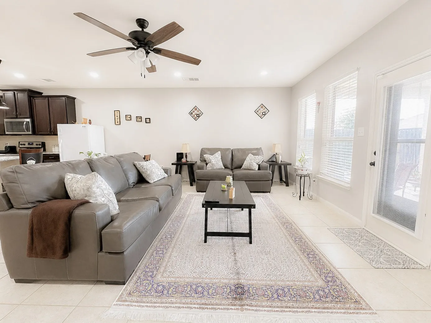 Bright living space featuring light-toned tile flooring, recessed lighting, and a ceiling fan with integrated lighting