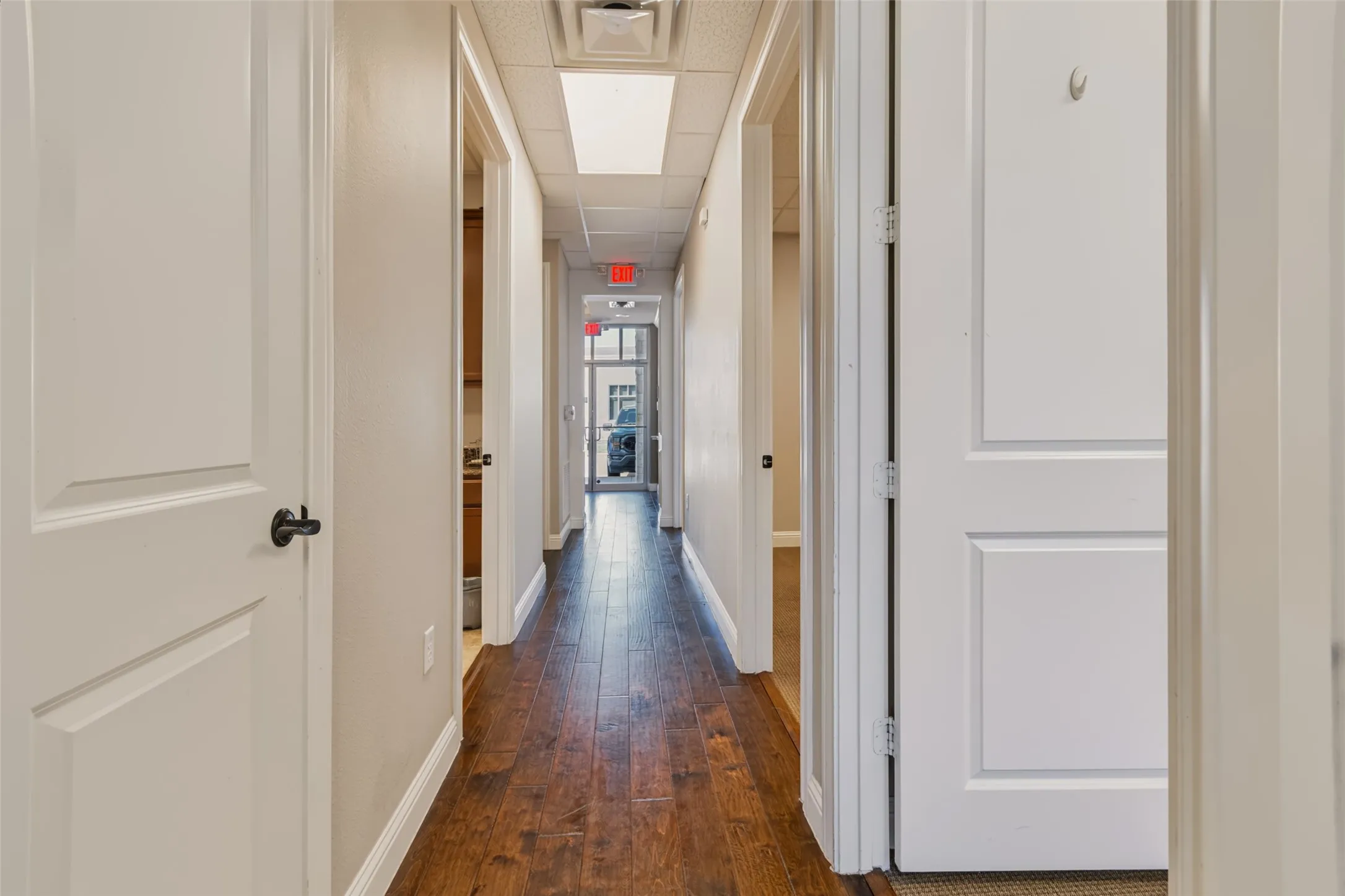 Hallway featuring wood-finish flooring, white paneled doors, and recessed lighting