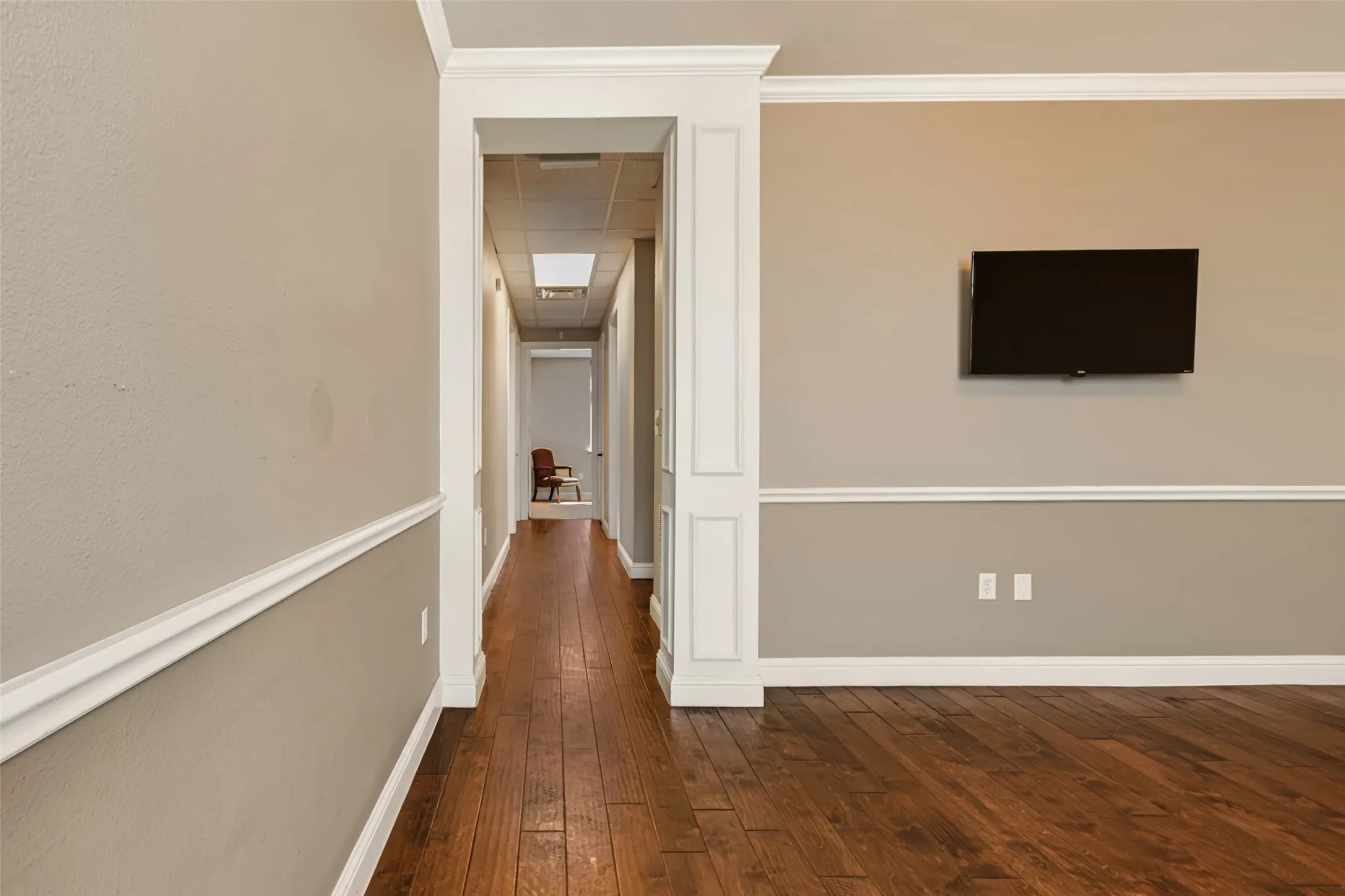 Wood-finish flooring throughout, featuring decorative crown molding and chair rail